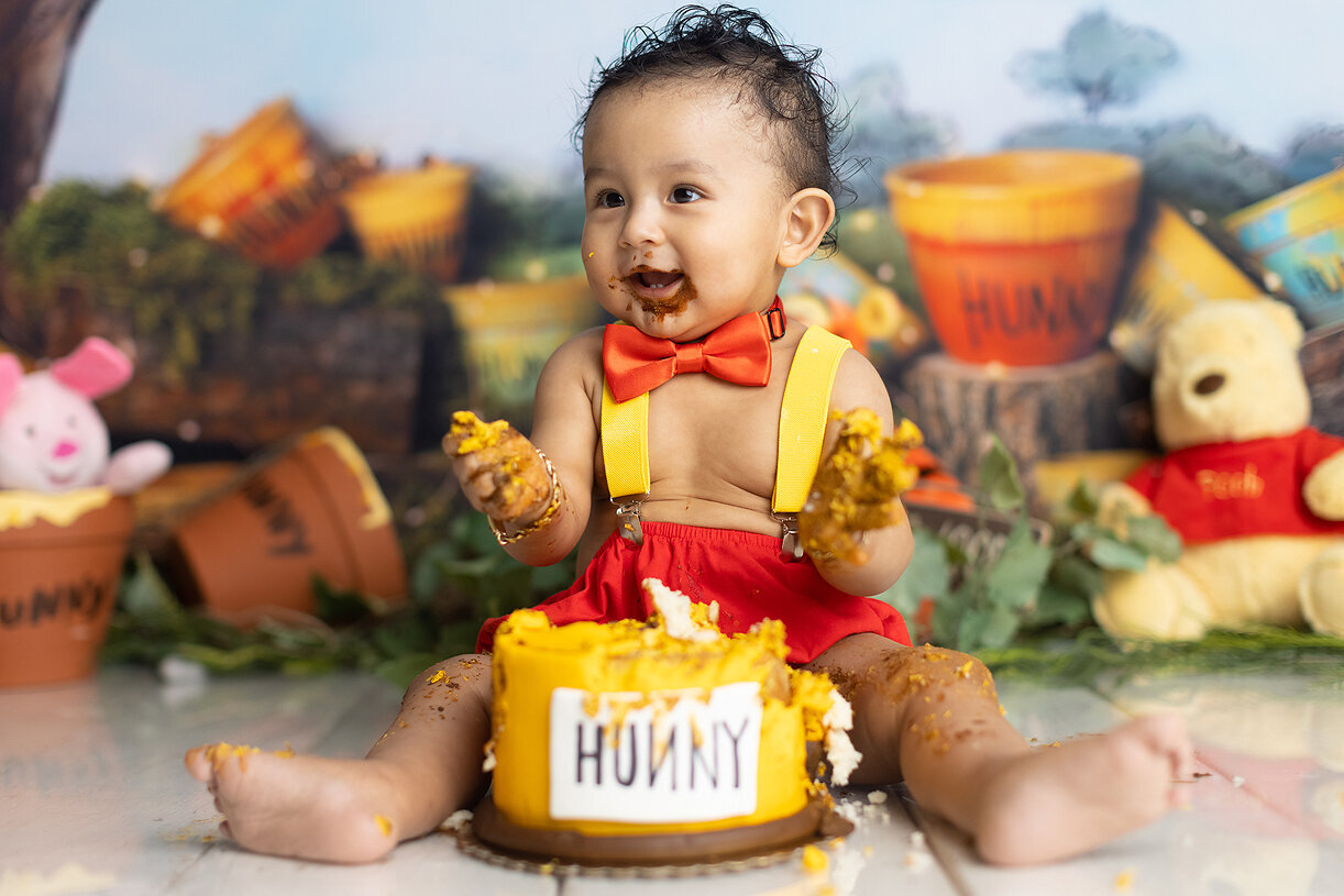 Boy eating cake at his cake smash.