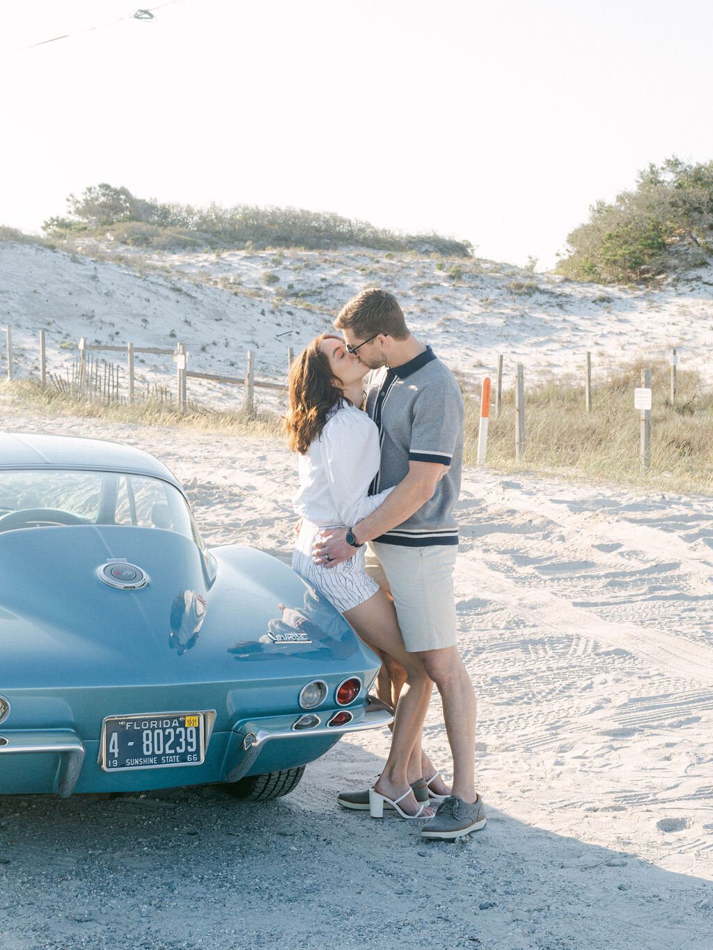 couple kissing in front of sports car at Seacrest Florida honeymoon