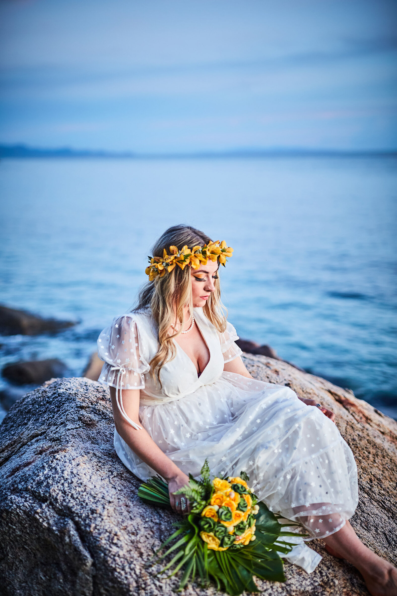 Bride sitting on rocks