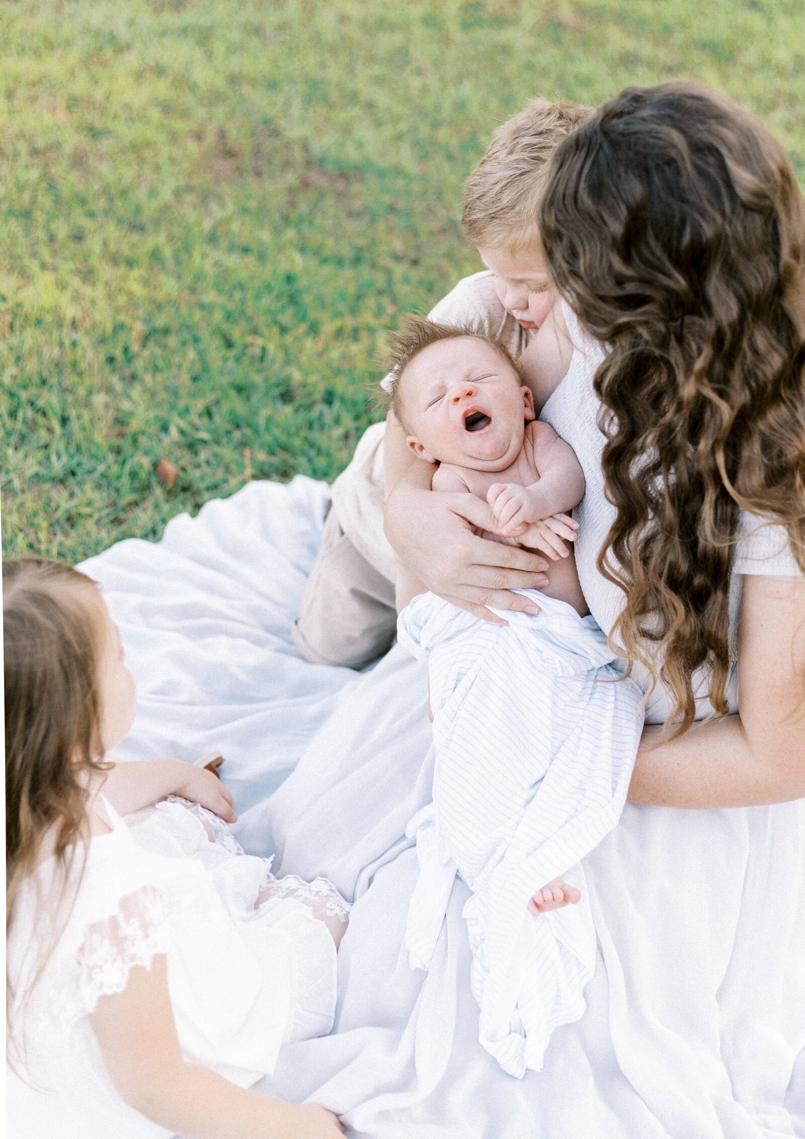 mom holding newborn baby with other children in peoria illinois newborn photos 