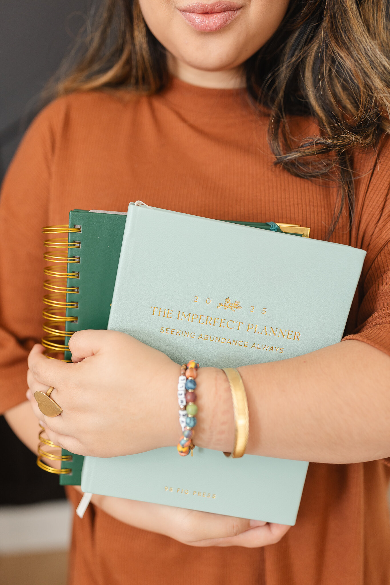 a woman holds her planners in her arms