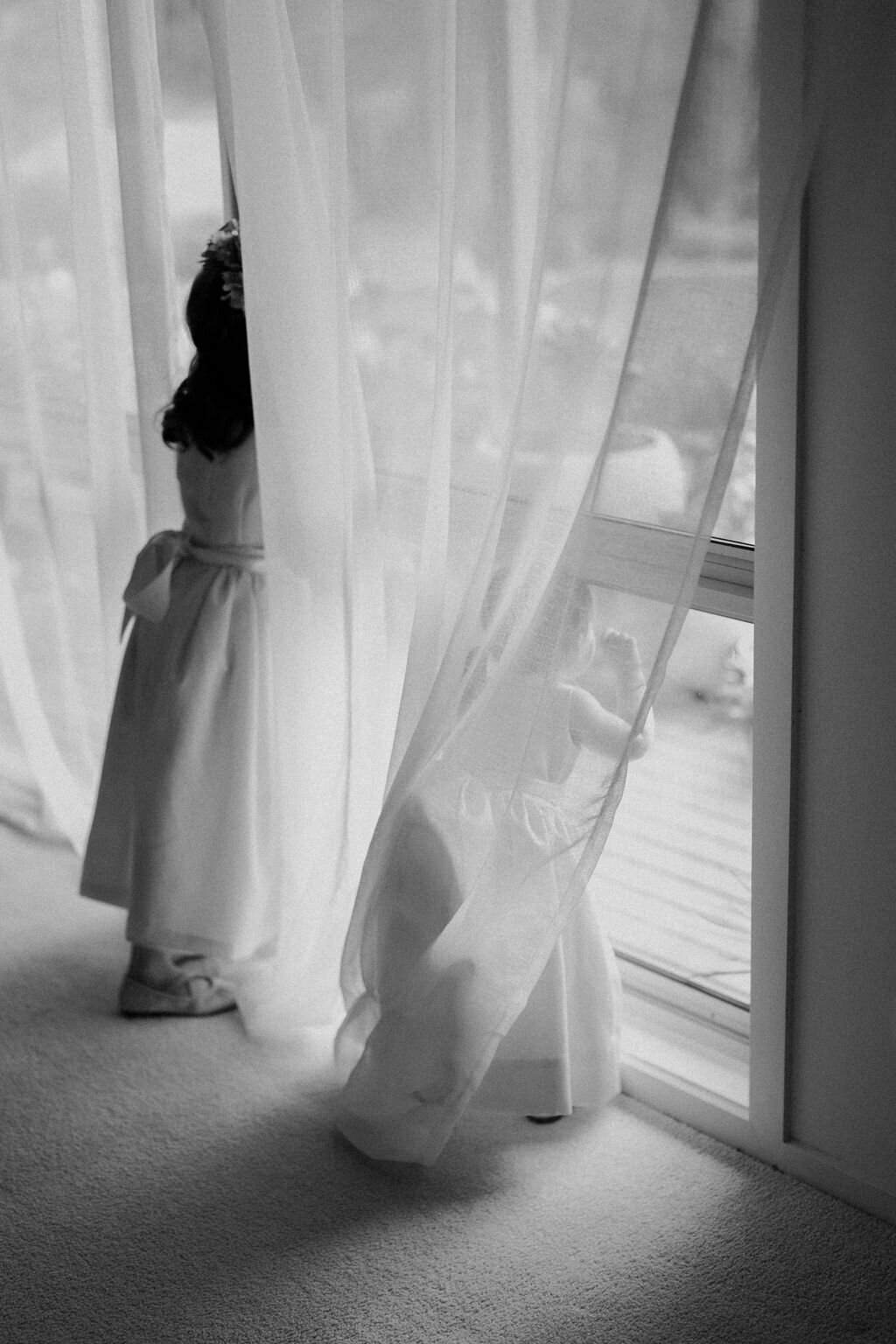 Kids looking through window at all the guests arriving for the ceremony