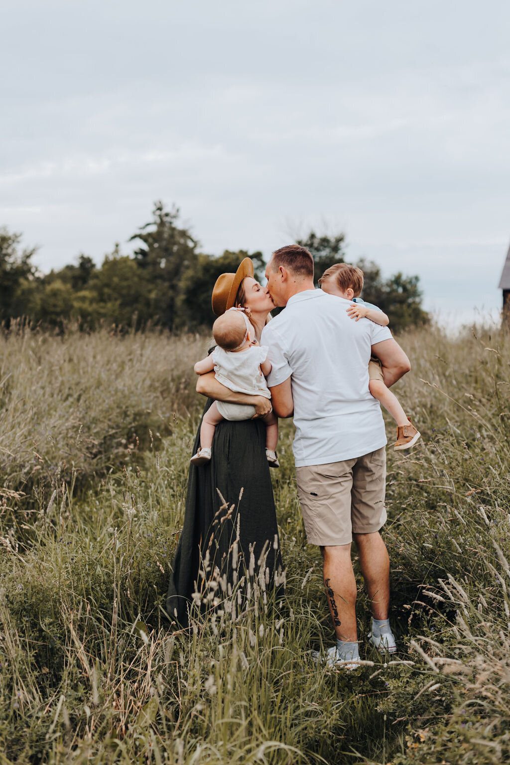 Parents kissing holding children