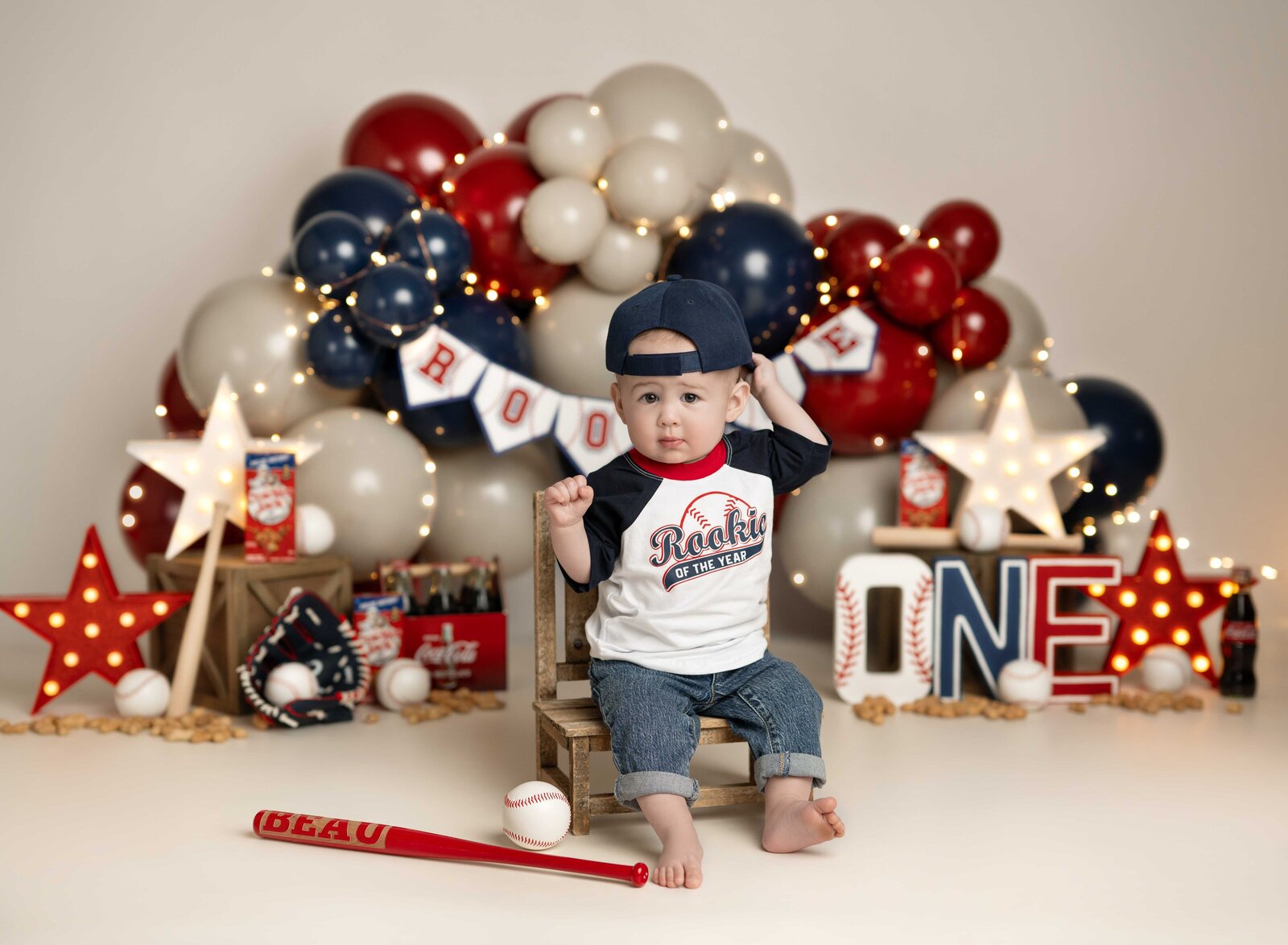 Rookie of the year theme cake smash set with baby boy in baseball shirt. Studio cake smash photo taken by Jenni Nikki Photography in Atlanta, GA.