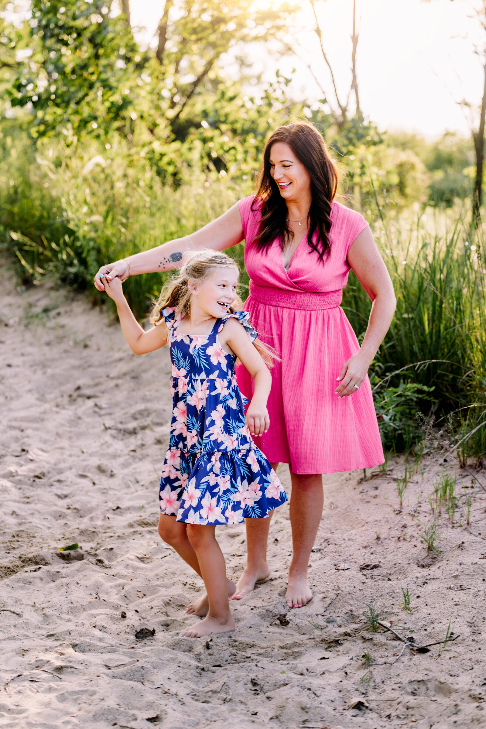 Mother dances wither her daughter on a path lined with tall grasses