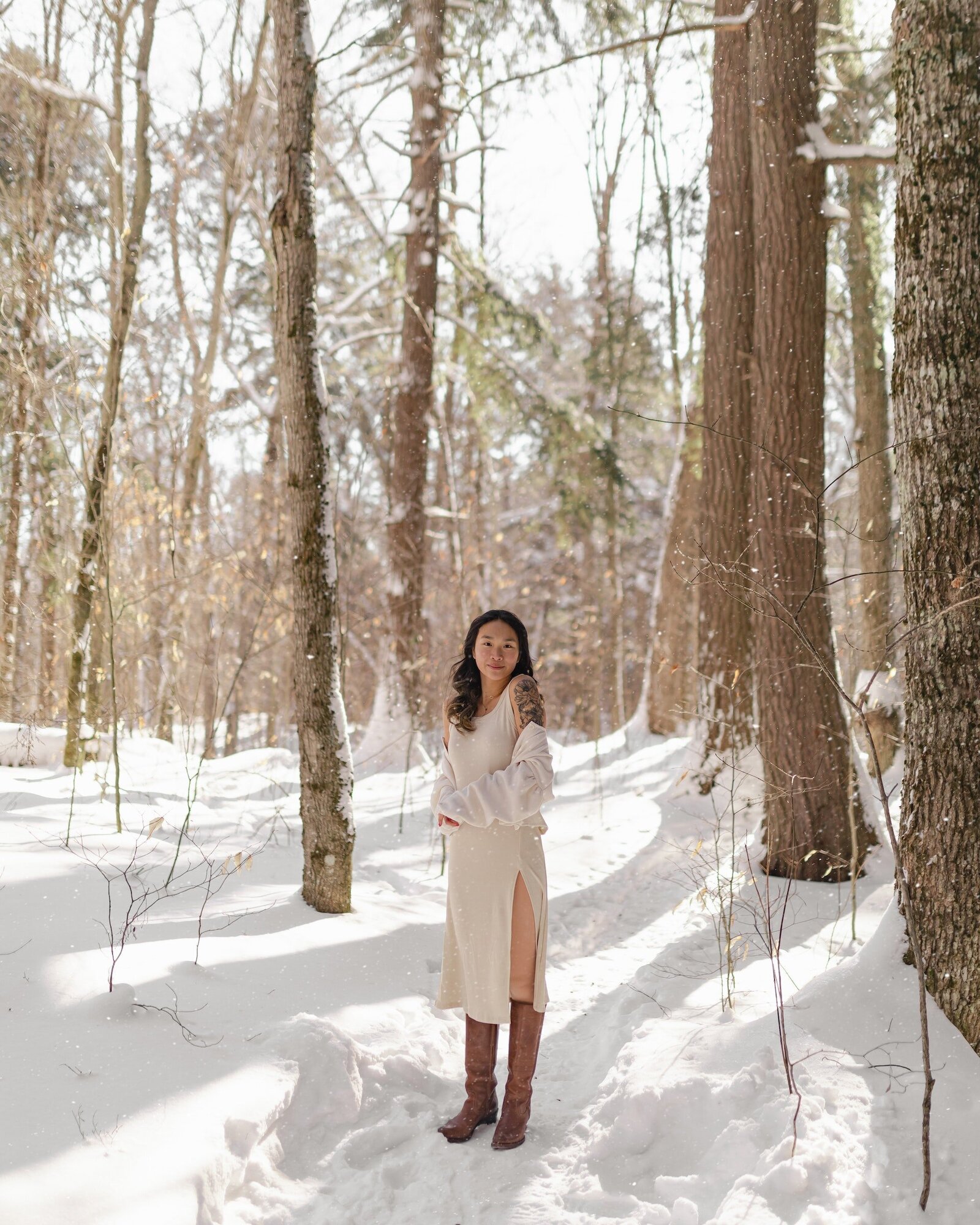 woman-with-tattoos-standing-in-forest-in-winter