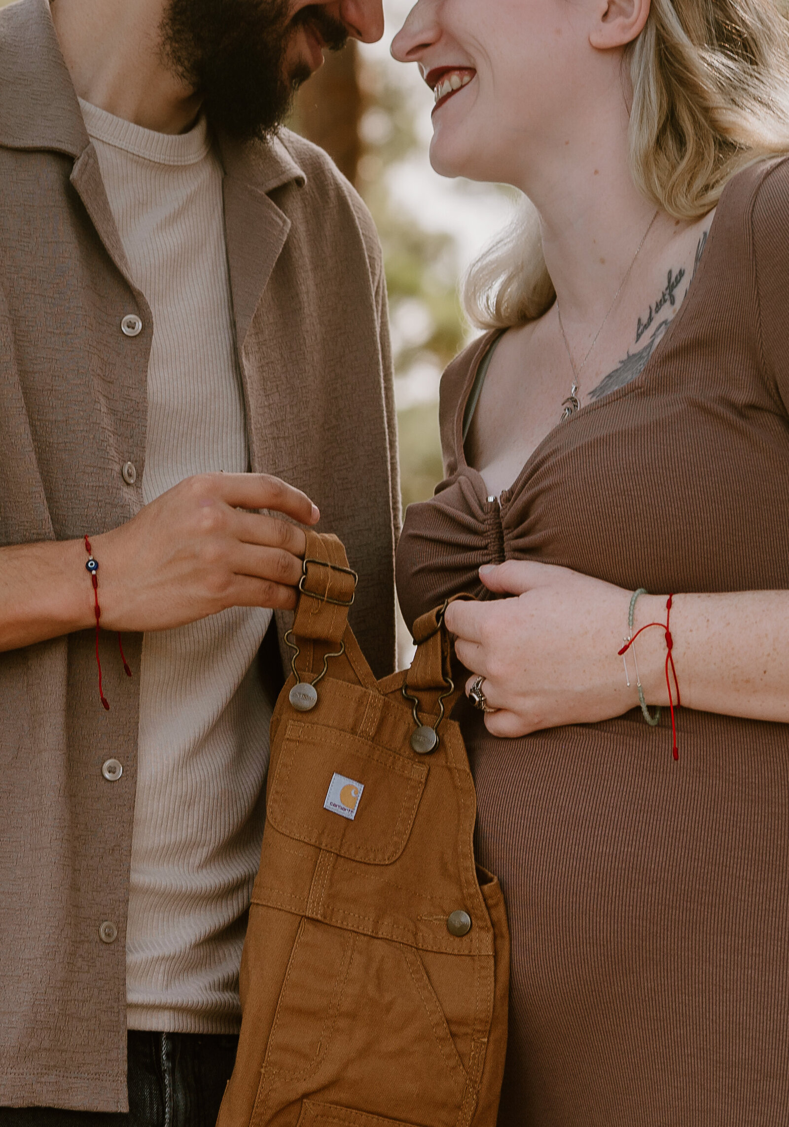 Close-up of expecting parents holding hands over baby bump during lifestyle maternity session in South Florida