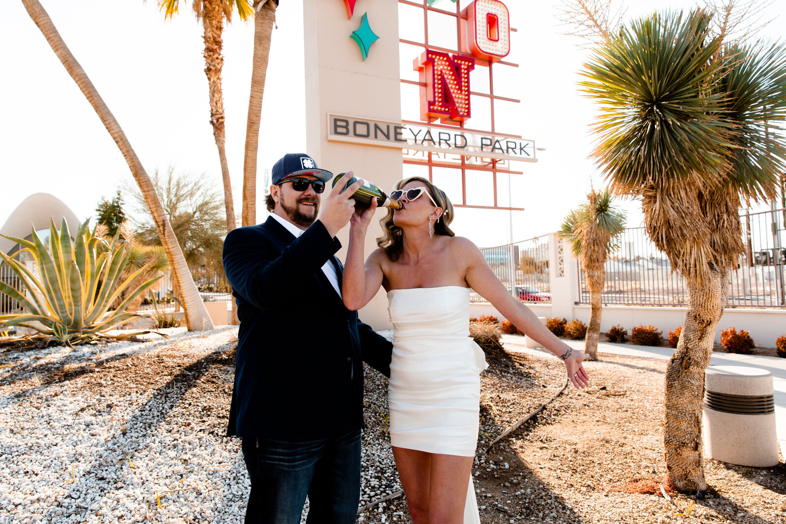 A couple celebrating with champagne at their Neon Museum elopement