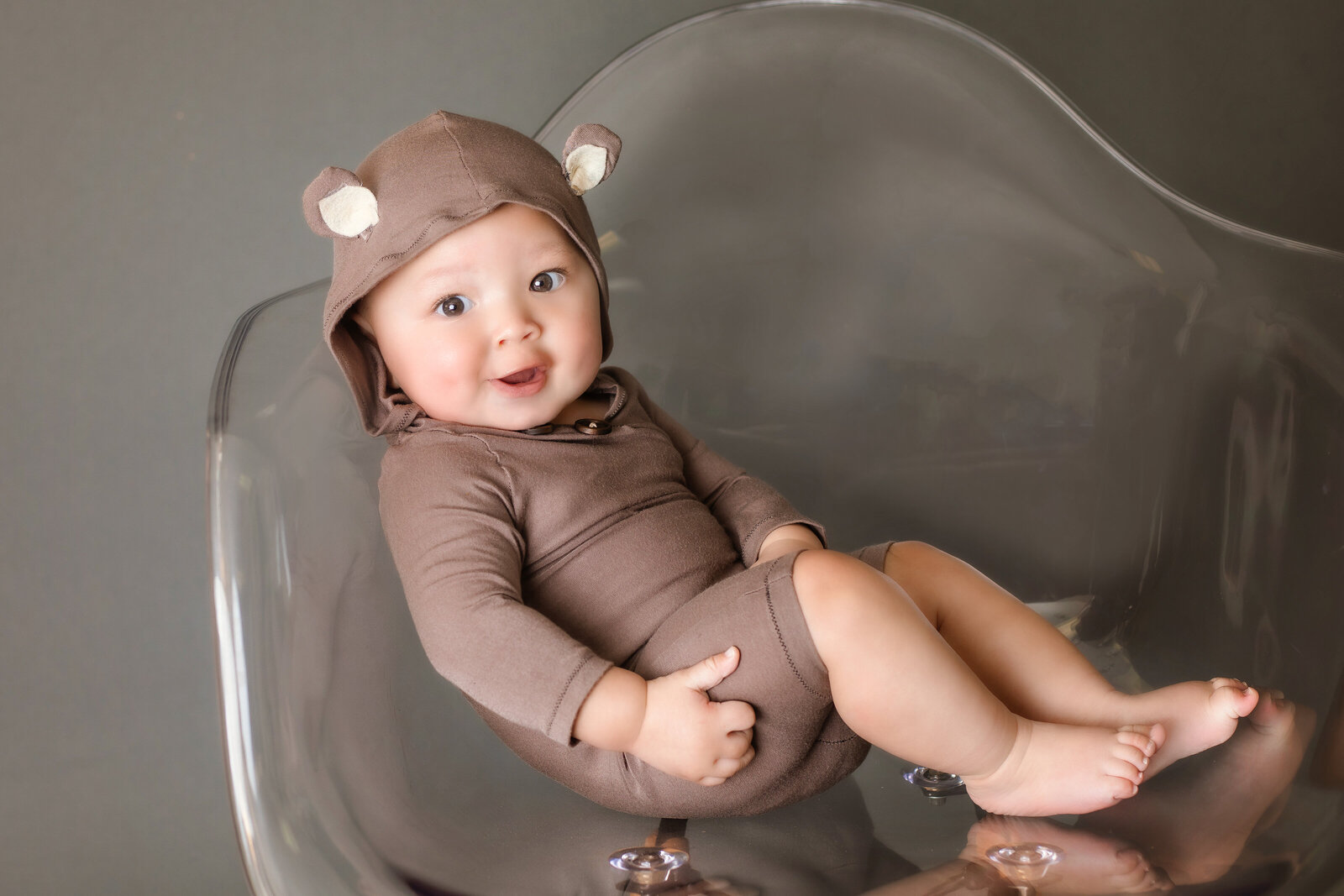 Milestone Photographer, a baby wears a small onesie with animal ears