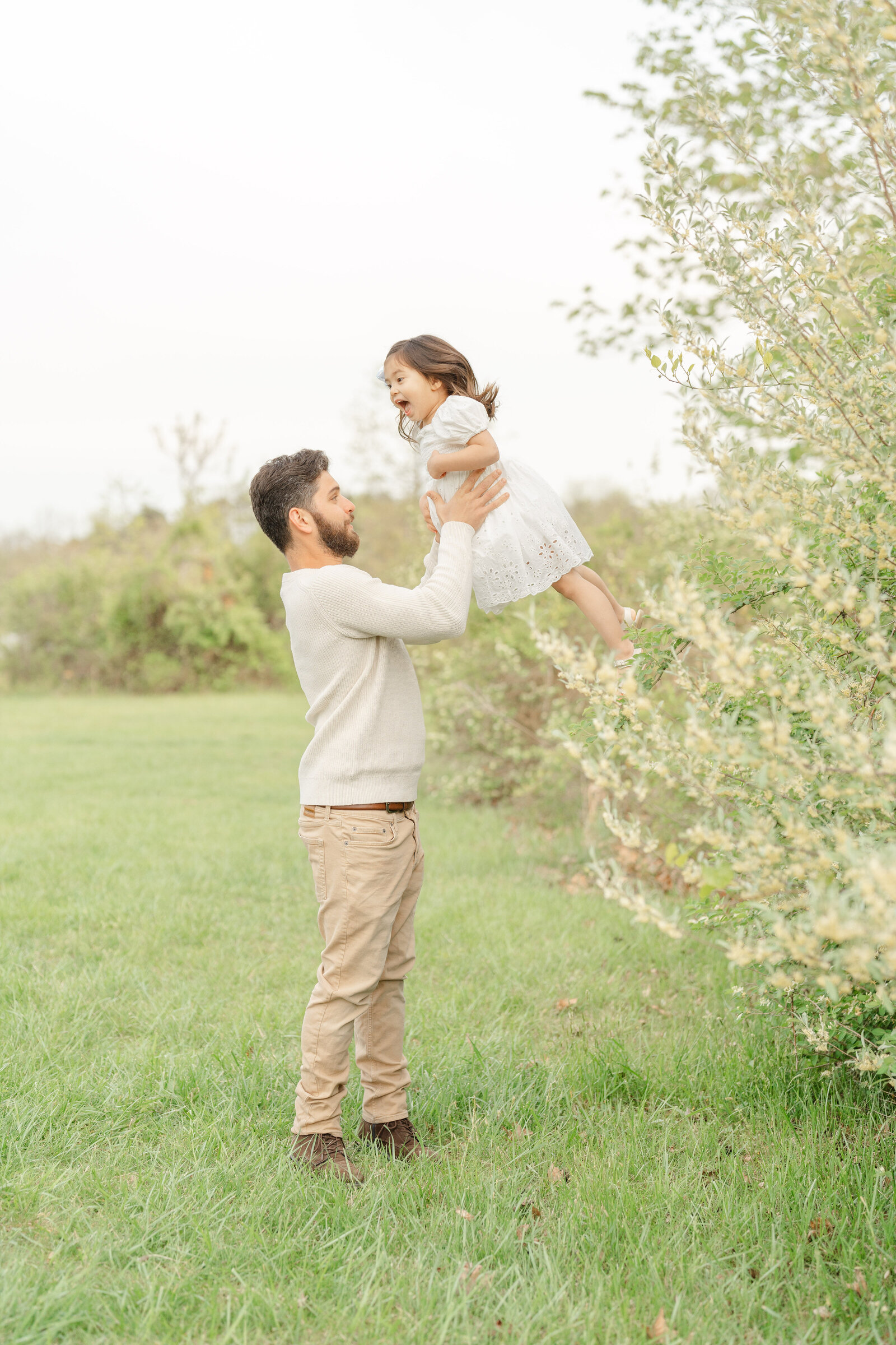 dad playing with daughter during spring mini session in Ashburn, VA