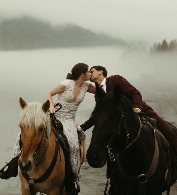 couple kissing while riding horses