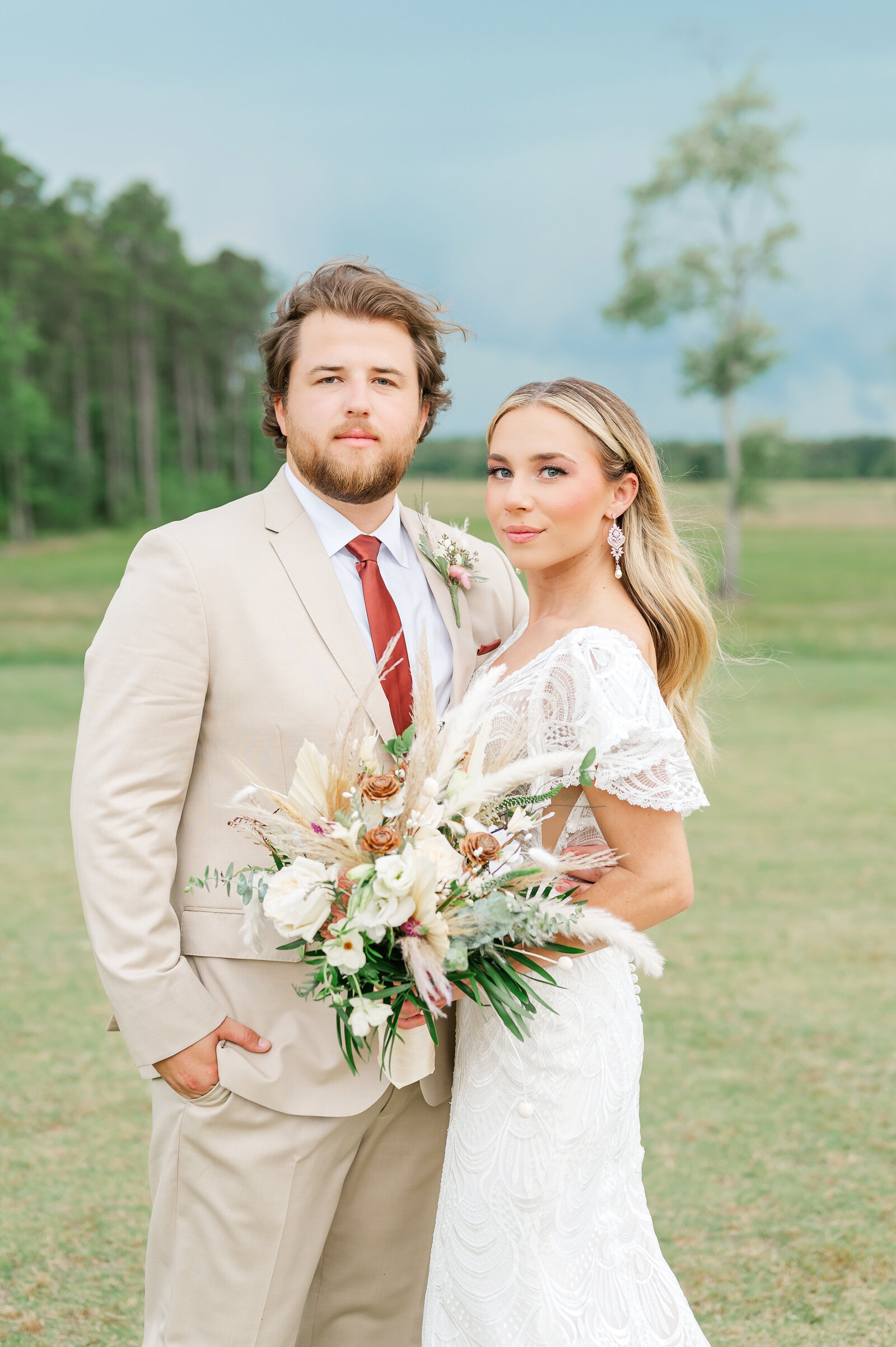Bride and groom portrait during moody clouds as a storm rolls in after their wedding ceremony at the Carolina Barn in Spring Lake, NC