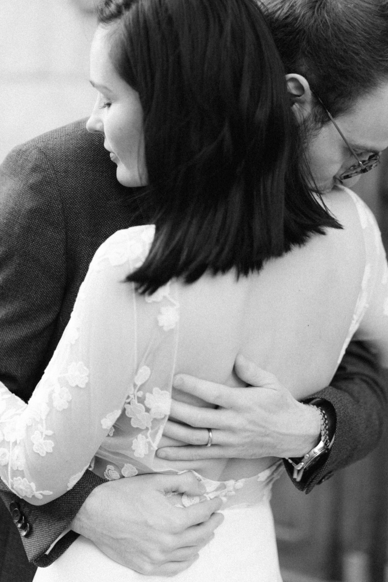 Hääpari halaa toisiaan hääkuvassa. Sulhanen suutelee morsinta olkapäälle. hääkuvaaja Hannika Gabrielssonin  kuvaama kuva.