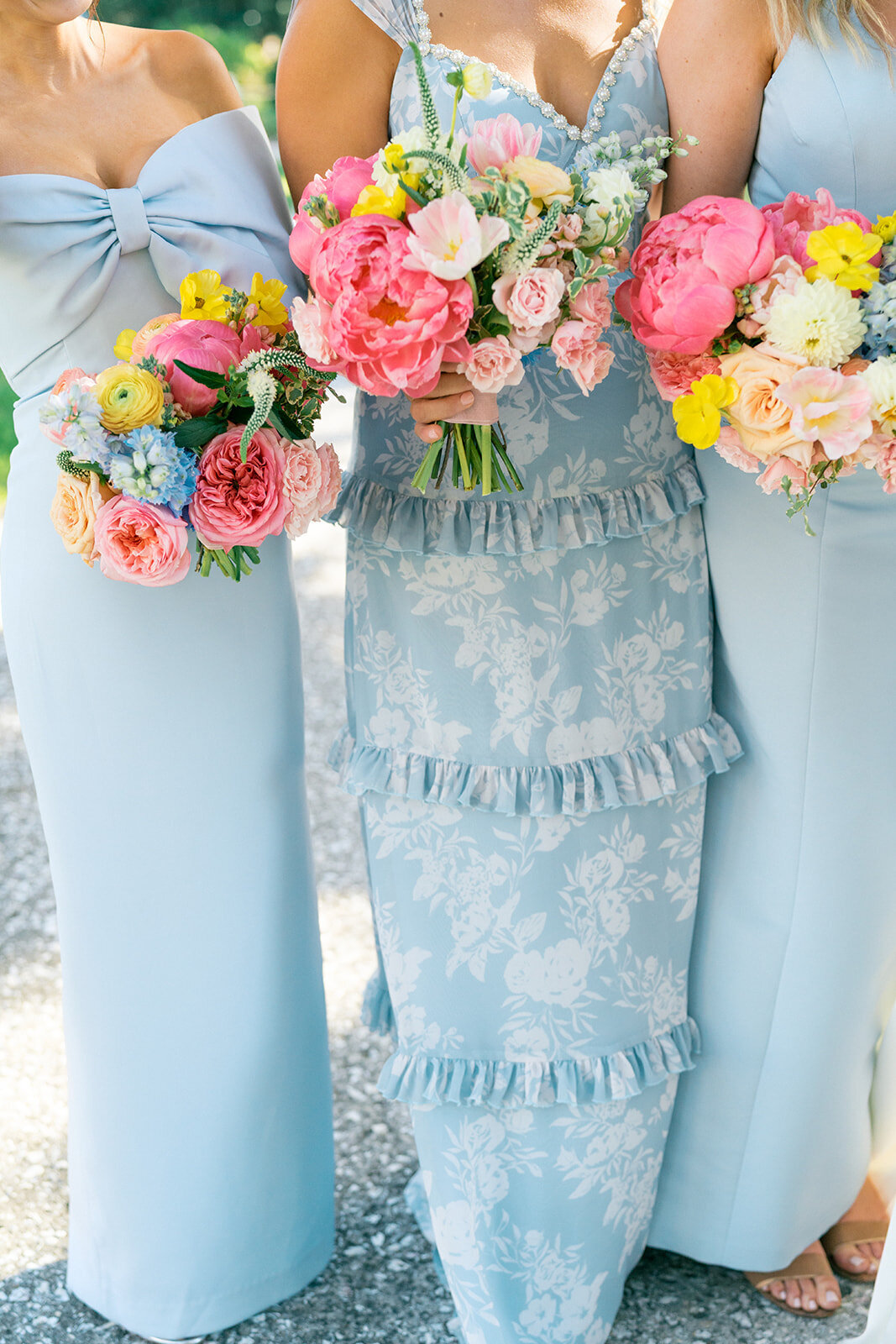 Bridesmaid dresses in light blue with bright pink colorful floral bridesmaid bouquets 
