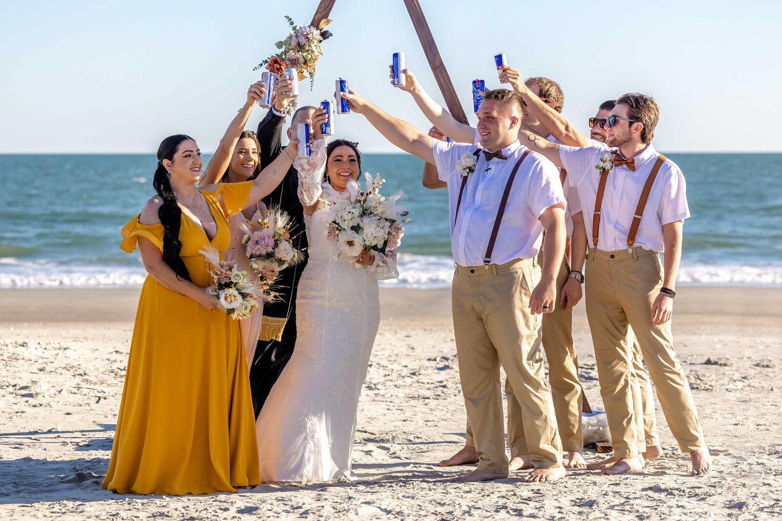 A vibrant group of wedding guests gathers on the balconies of a beach house in Topsail Beach, NC, celebrating love and coastal charm, with a pool and playful decor adding to the fun atmosphere.