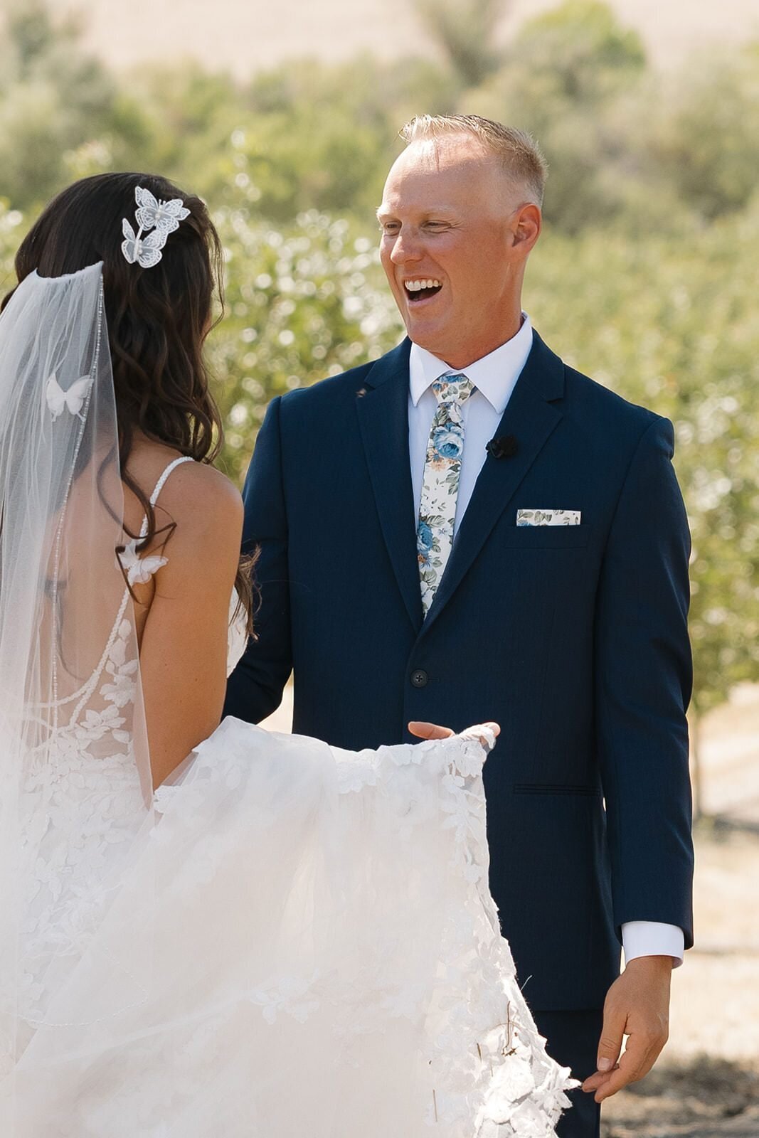 Groom laughing as he sees the bride for the first time in a pistachio orchard
