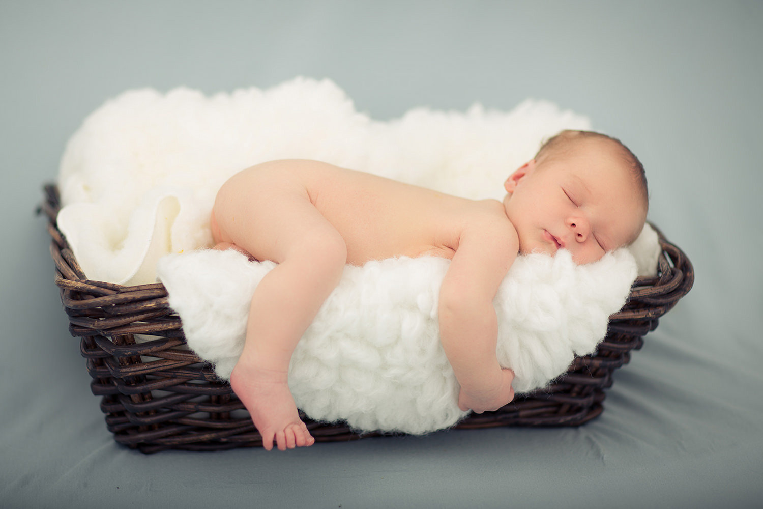 san diego newborn photographer | newborn sleeping in wicker basket with white blanket