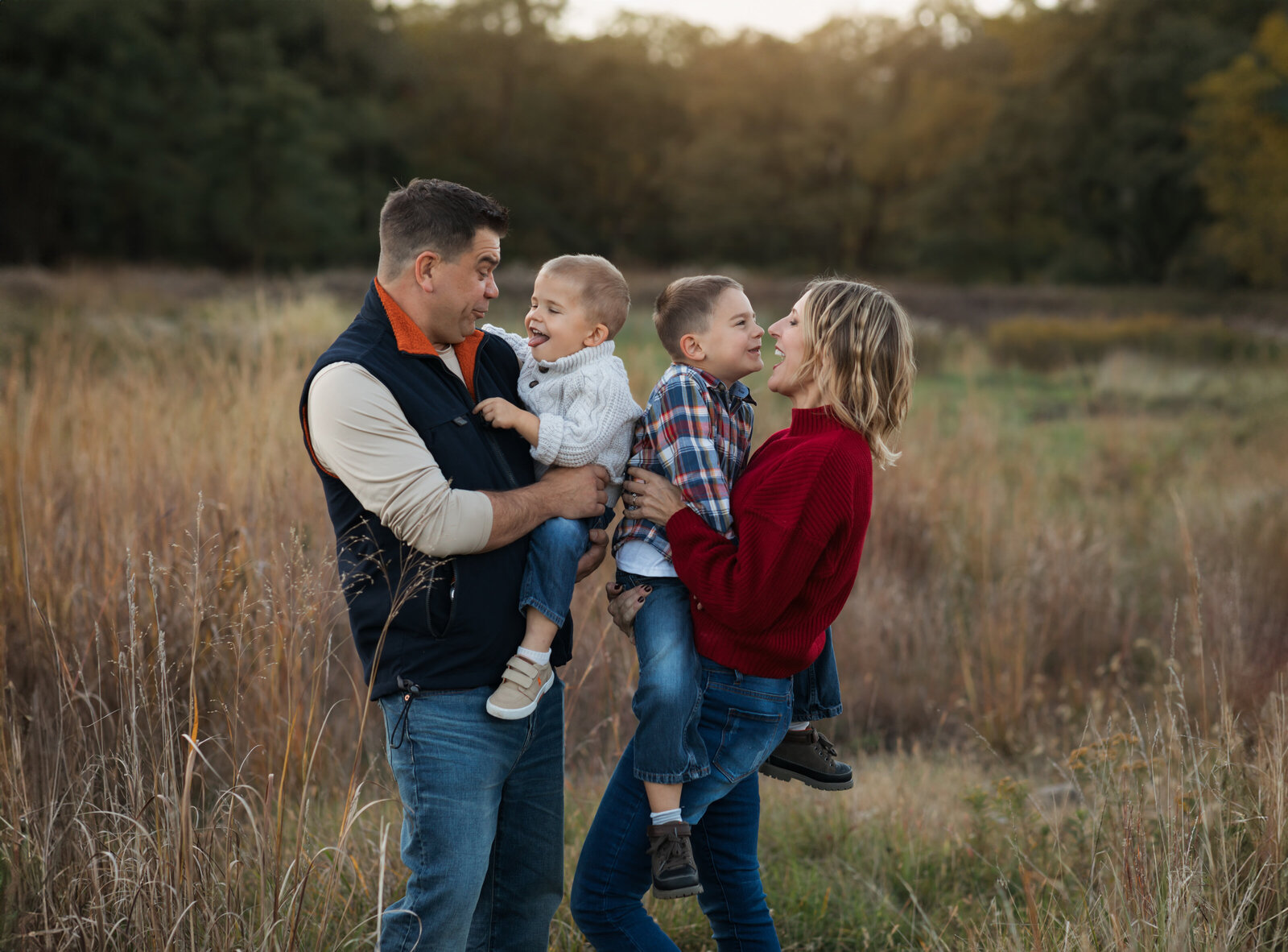 mom and dad with two sons posing in park for family photos at westcreek reservation in parma ohio