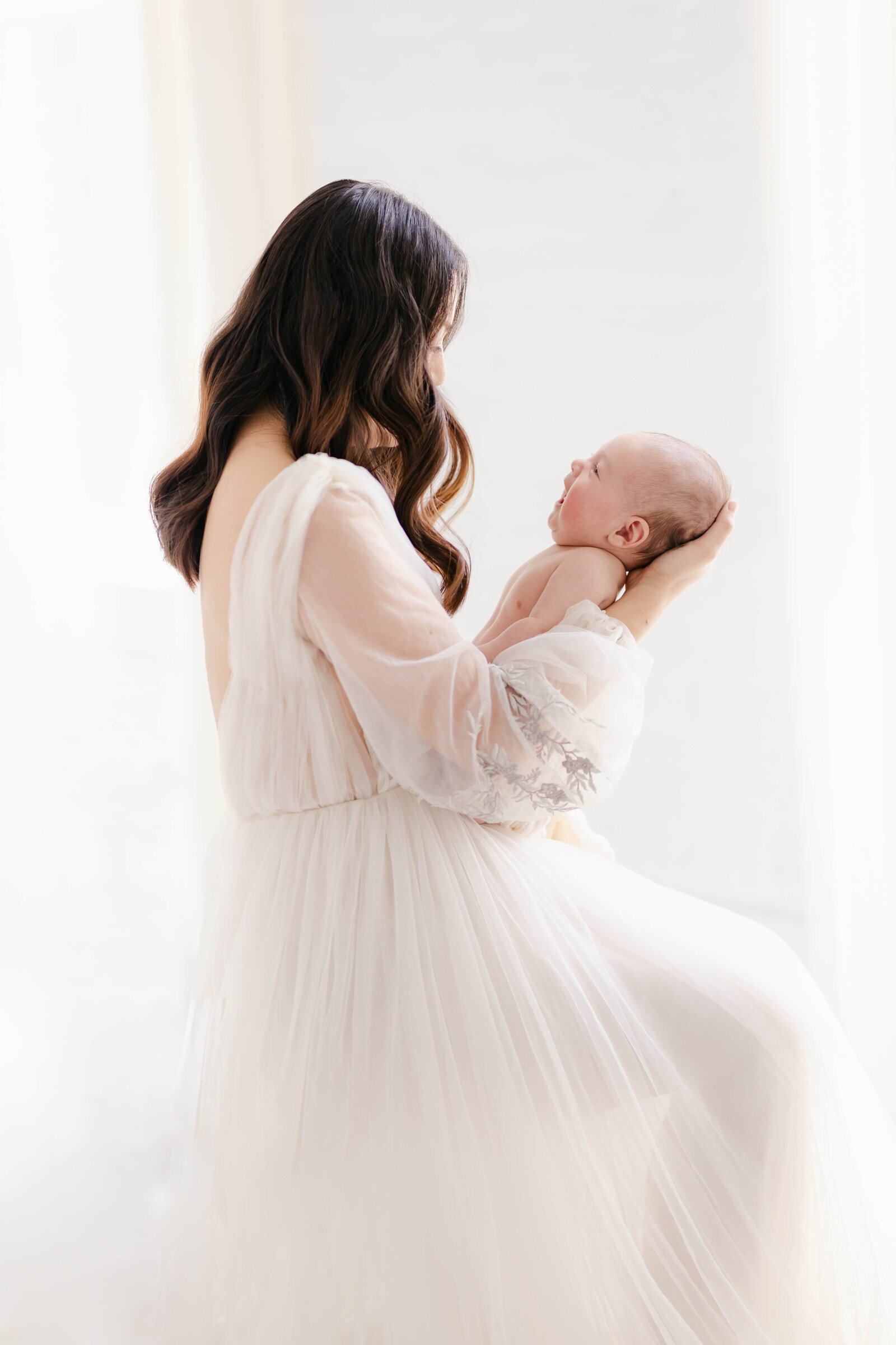 Newborn held closely by the mother, showcasing their connection, photographed by Bay Area Newborn Photographer, Laurel Smith.