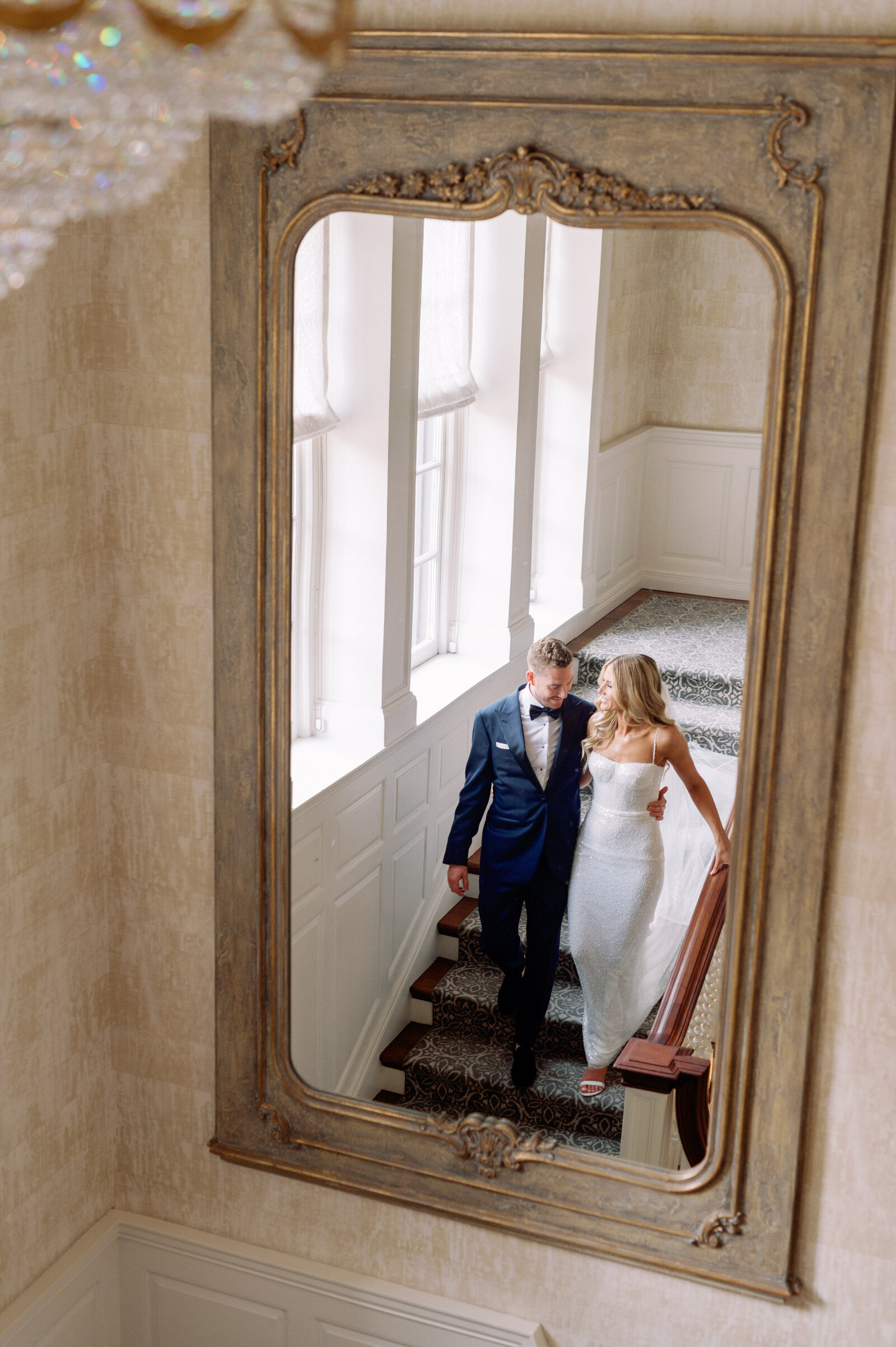 Editorial Classic Couples Portrait walking down staircase at Graydon Hall Manor Toronto Wedding | Jacqueline James Photography