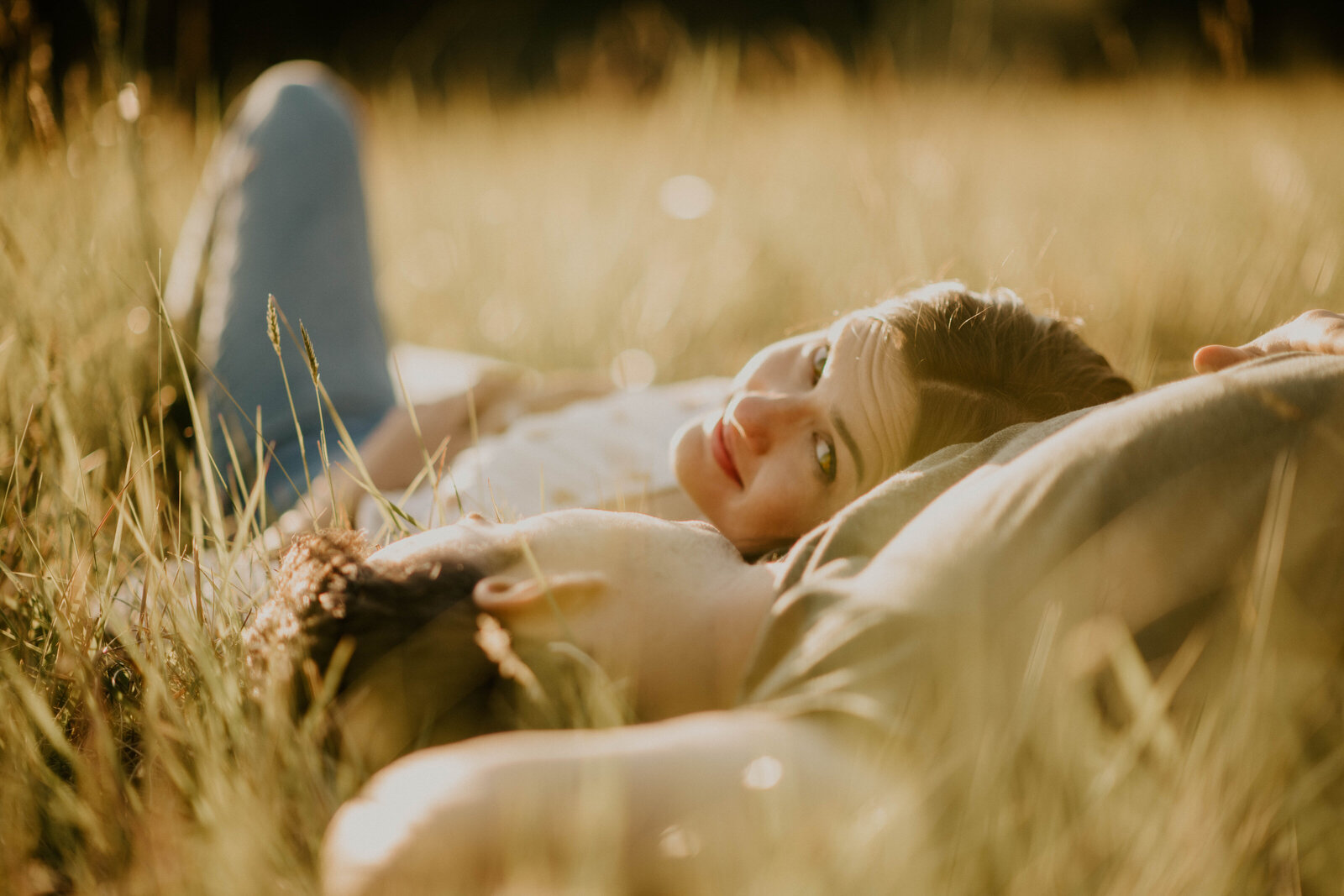 Couple laying in a field at golden hour