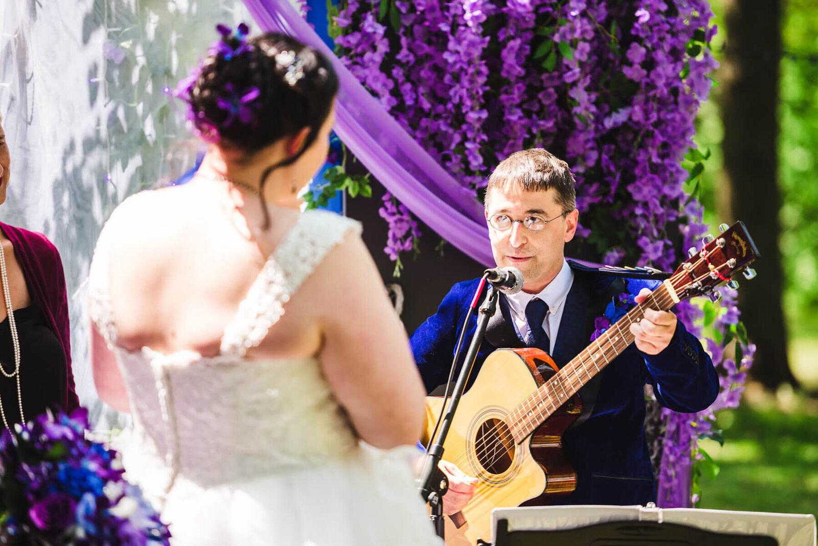 Groom playing guitar for wedding vows