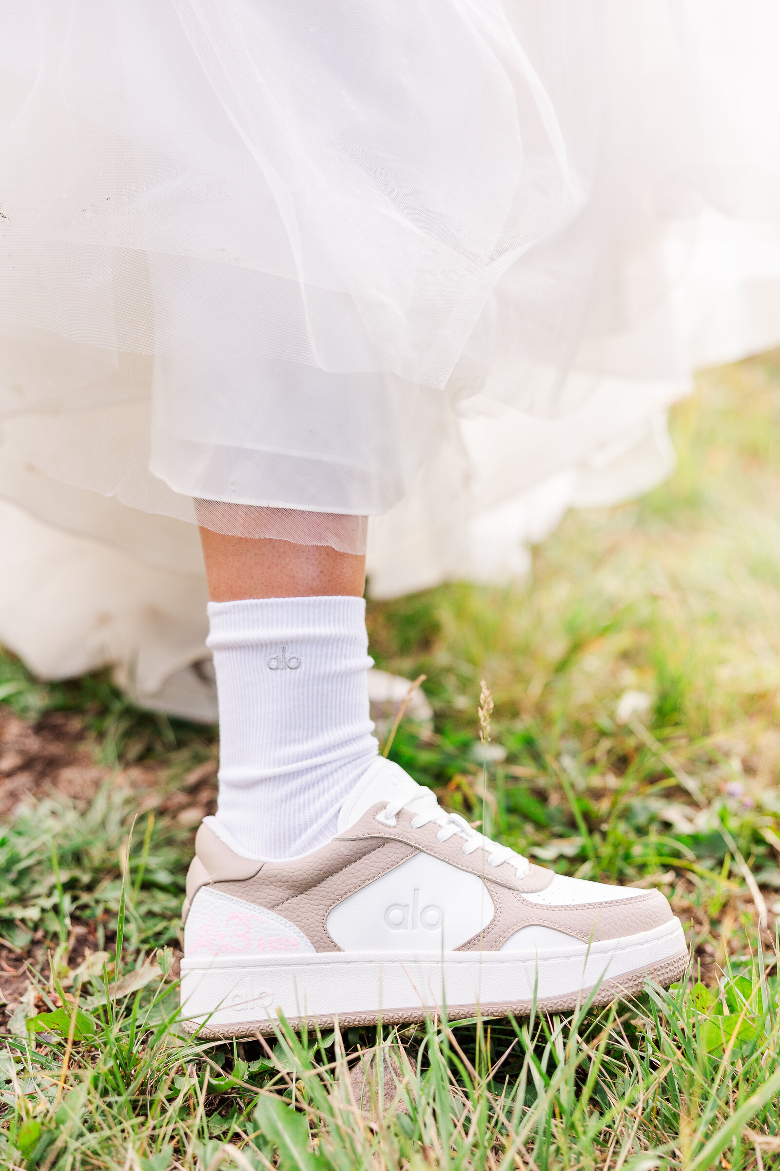 Detail image of bride showing off her custom made shoes for her wedding reception