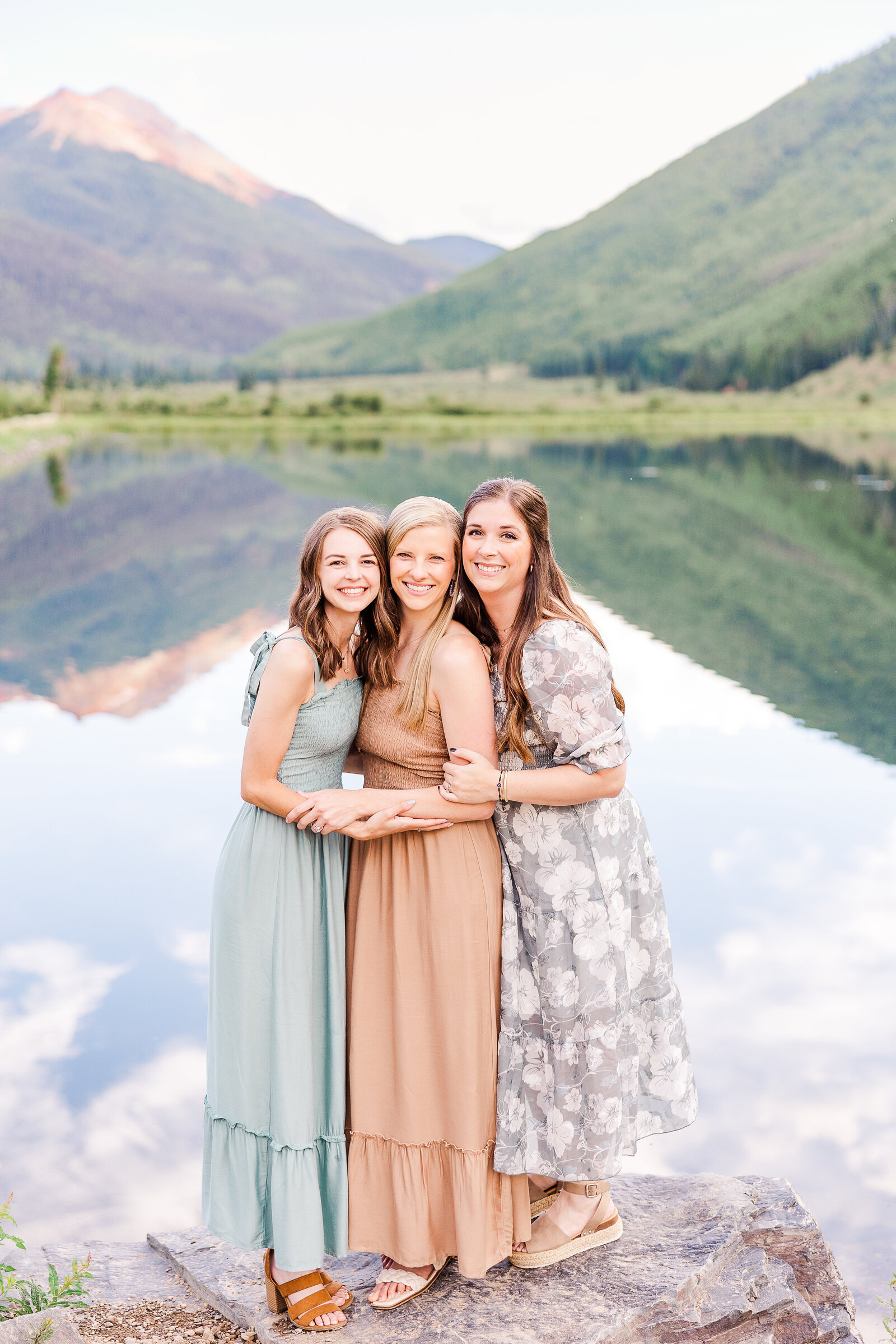 sisters pose in front of lake