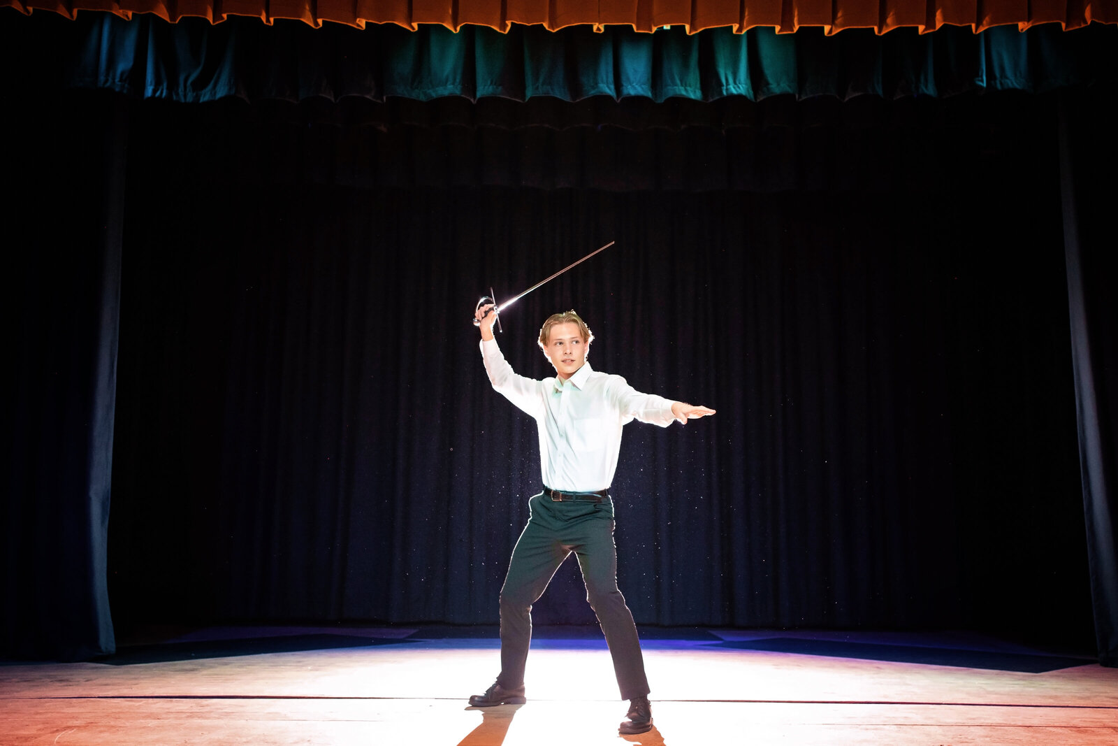 high school senior poses with sword at theater