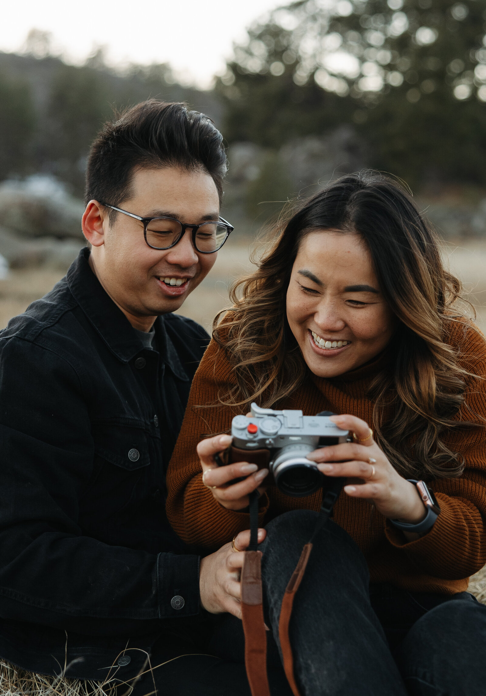couple looking at a camera, looking at photos of themselve