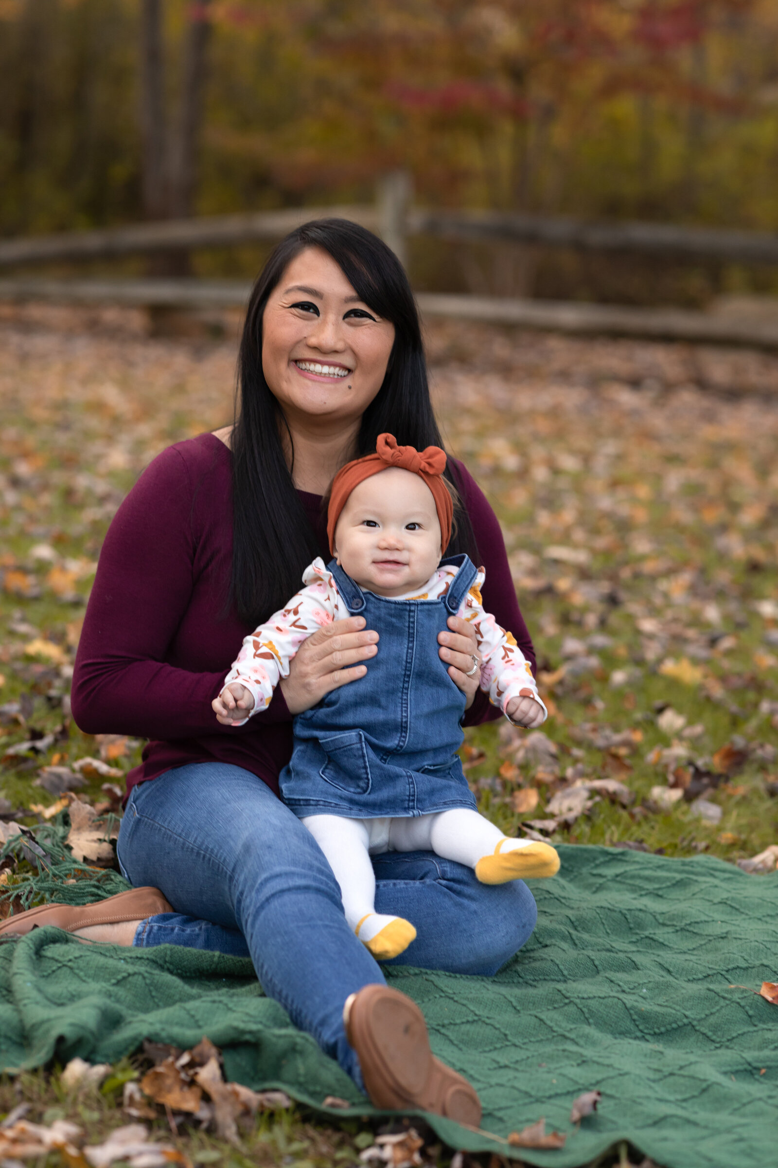 mom holding baby girl in park for family photos