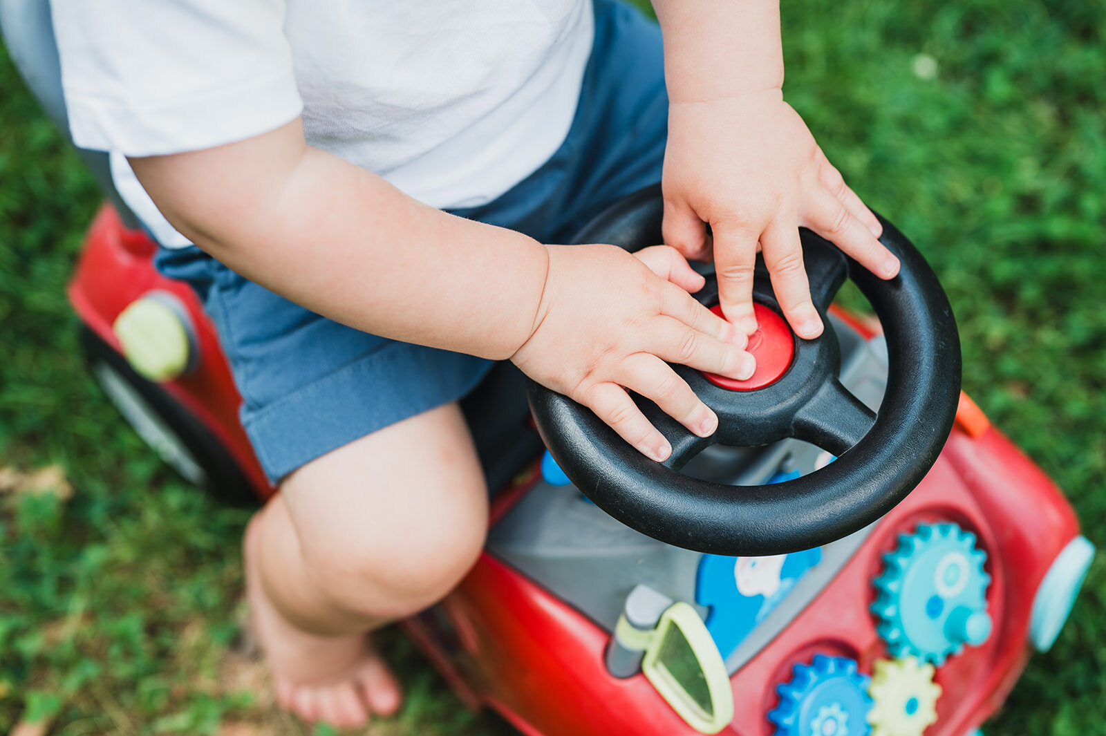 toddler-hands-on-toy-steering-wheel-candid-photo