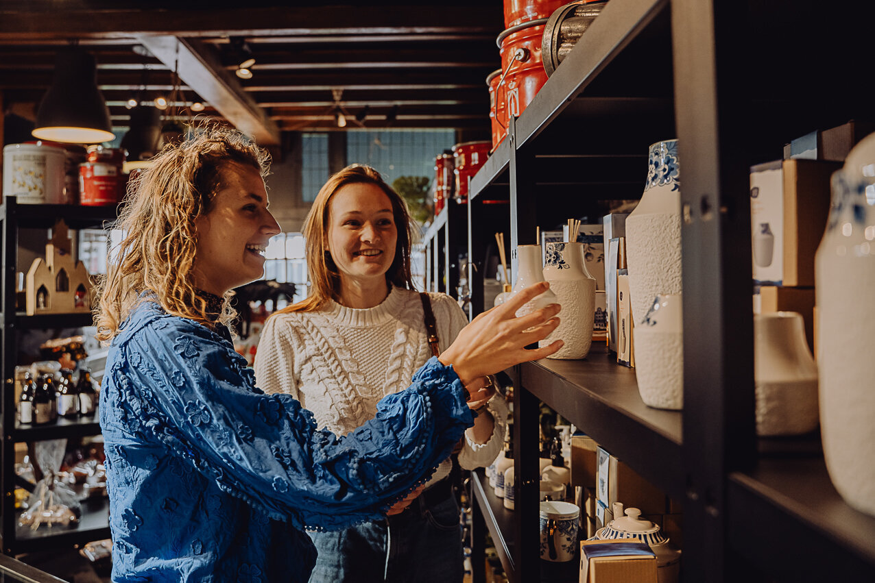 Dames bekijken Delfstblauwe vazen in de winkel. 