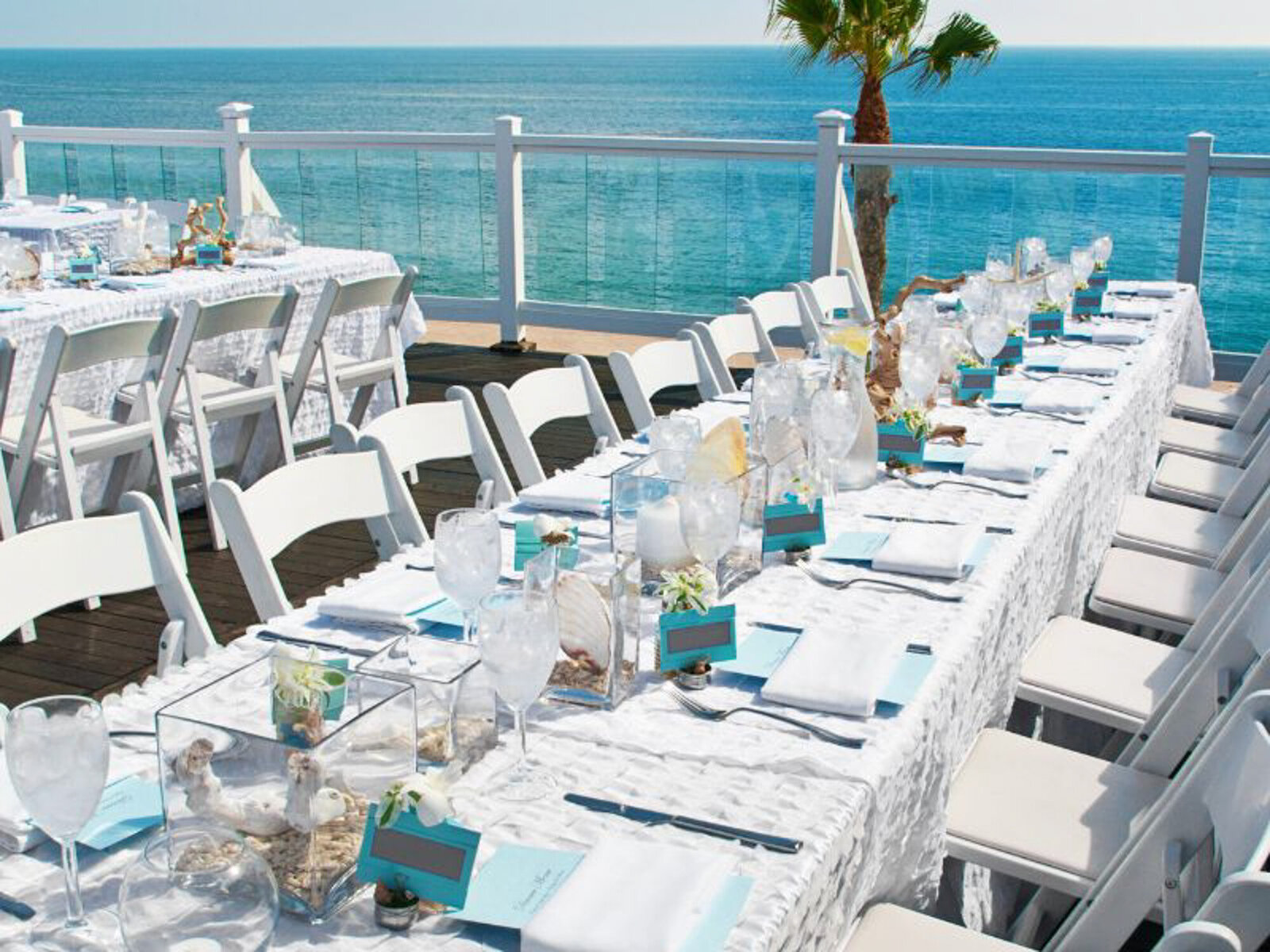 Elegant wedding reception tables and chairs with ocean view