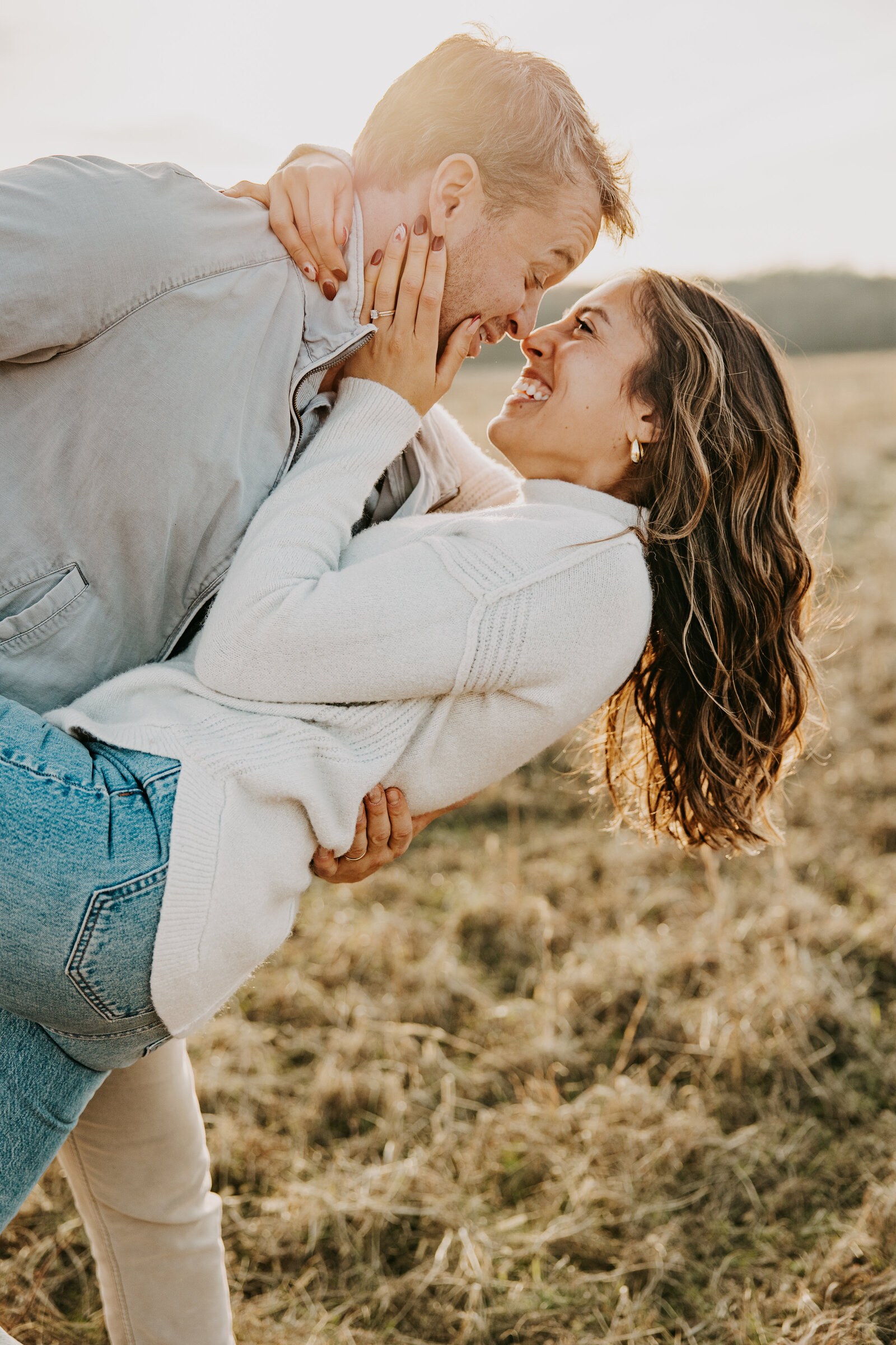 Kelly and Jordan in a sunlit field at Shelby Farms, embracing and smiling, with golden sunlight glowing behind them.