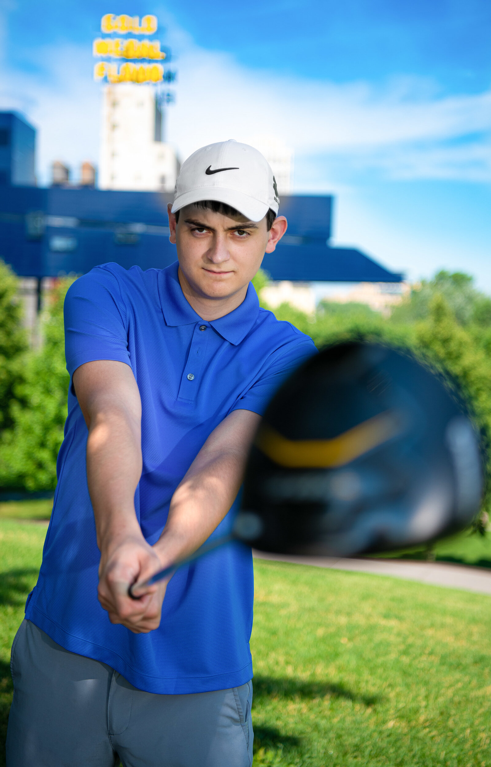 Senior boy dressed in blue with a golf club