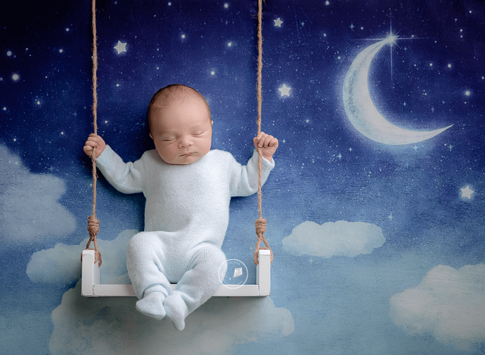 newborn boy with moon backdrop