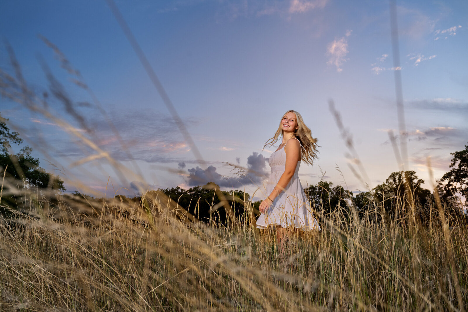 Mounds View Minnesota high school senior photo of girl in white dress in long grasses