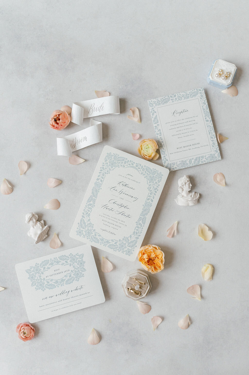 a flat lay with wedding stationery and flower petals