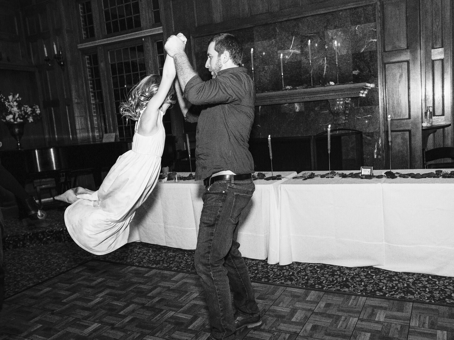 Wedding guest swings his daughter around on the dance floor