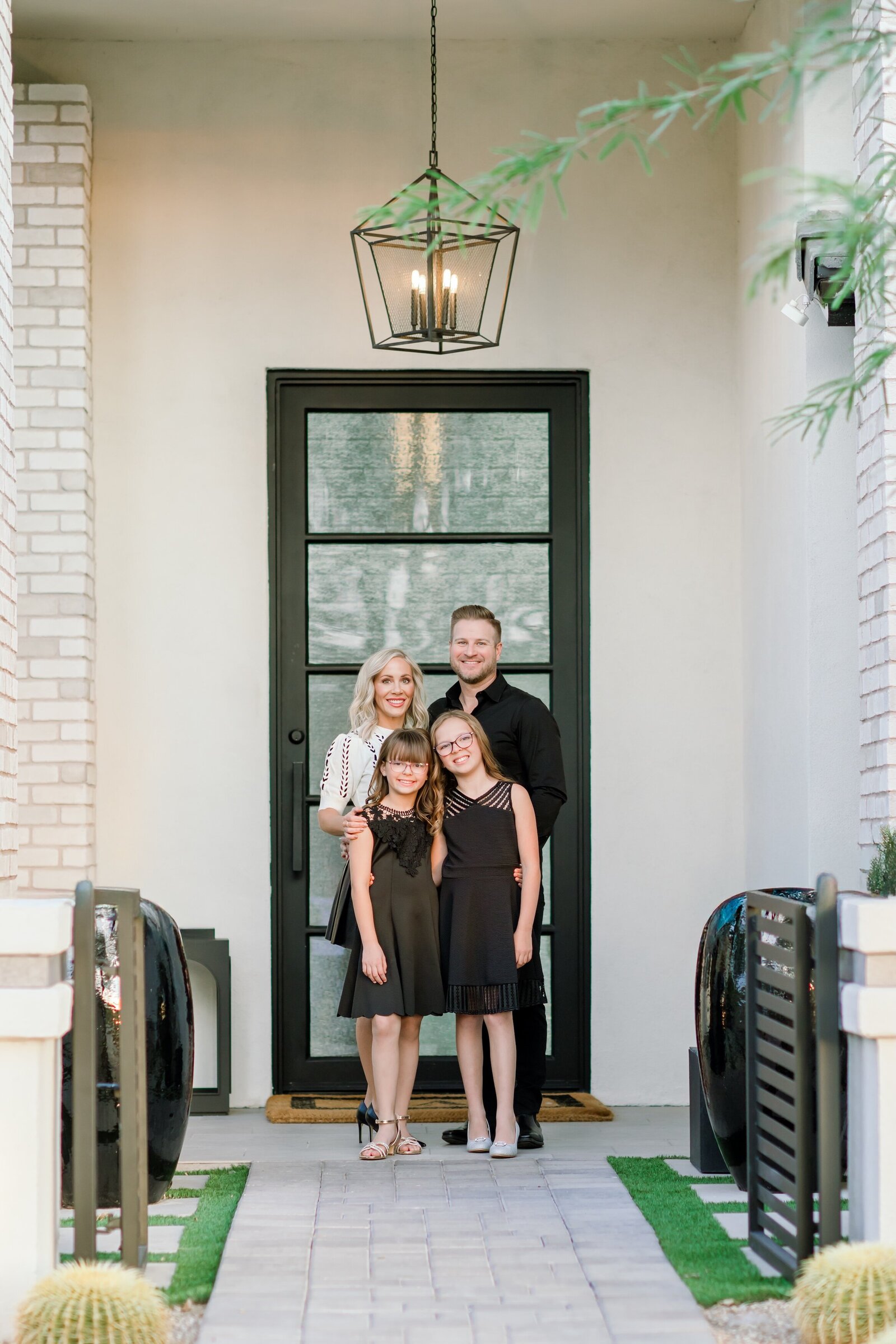 family posing for family photos by their home in north scottsdale