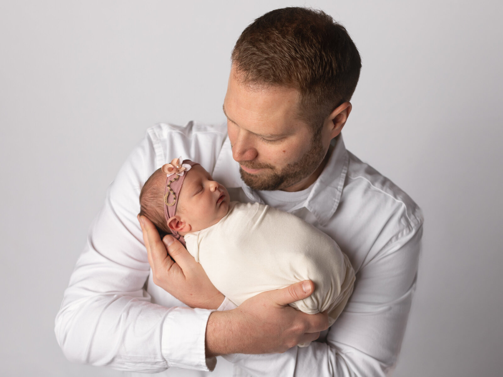 dad holding newborn baby boy for studio portraits