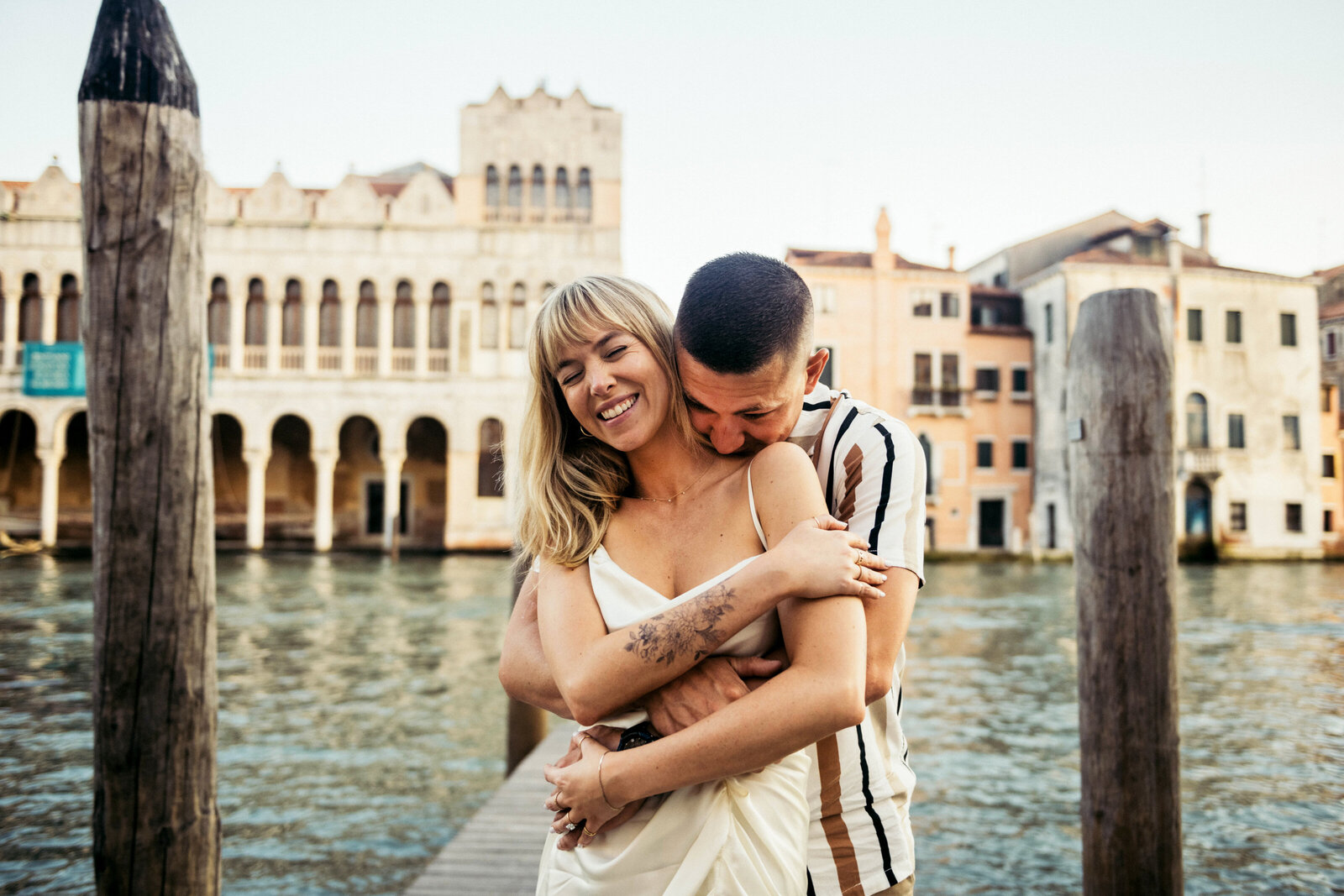 A couple hugging during their engagement photoshoot in Venice Italy, Canal Grande on the background