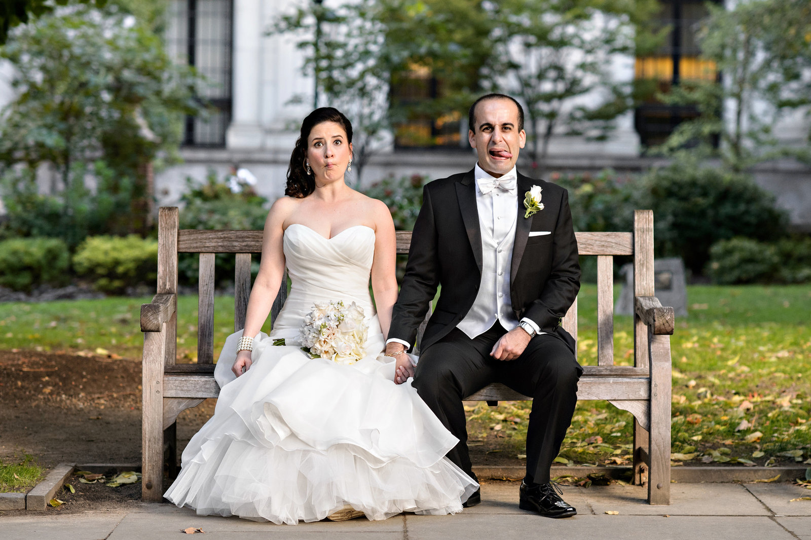 A wedding couple making funny faces in Washington Square Park in Philadelphia.
