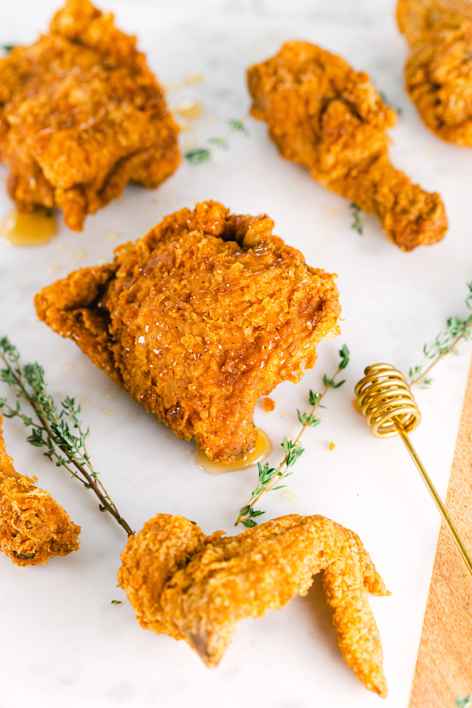 Chelsea Loren Branding Food Photographer in San Diego styled fried chicken with hot honey and thyme on a marble backdrop.