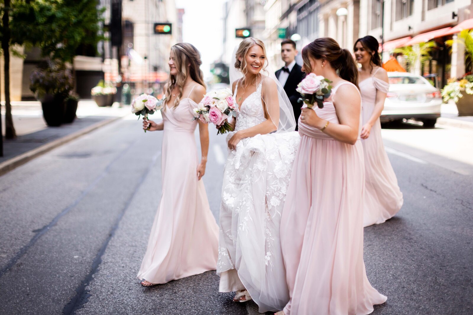 Capture the vibrant energy of Hailey and her bridesmaids as they cross the street in style, creating a lively and fashionable moment on her wedding day. This charming photograph showcases the group in motion, dressed in their elegant wedding attire, against the bustling urban backdrop. The image beautifully combines the excitement of the city with the joy of the wedding festivities, perfect for brides looking for dynamic and contemporary bridal party photo ideas.
