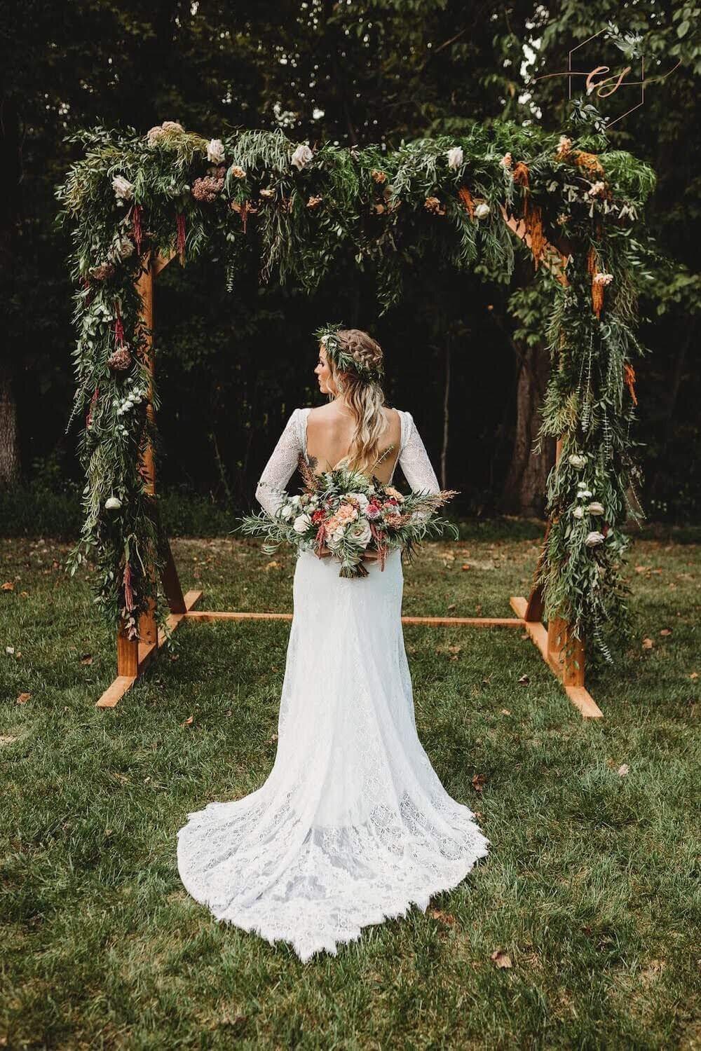 Sydnee Chaille wedding - bride holding floweres in front of pergola