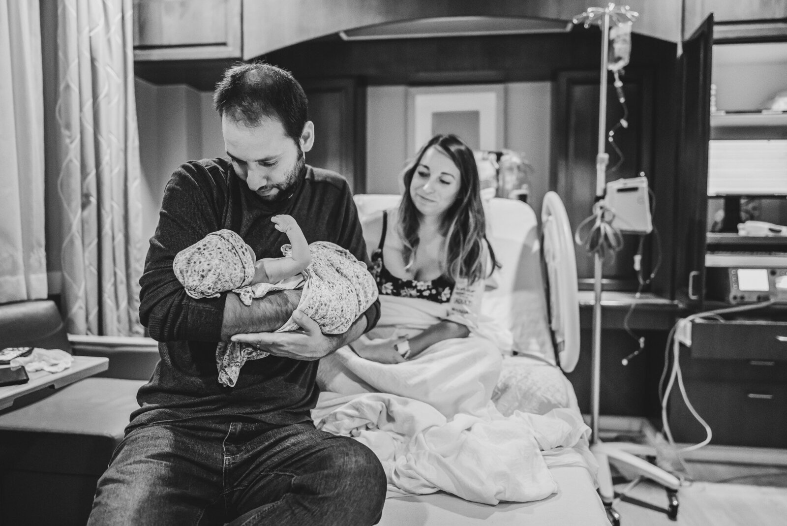 dad holding newborn baby in hospital