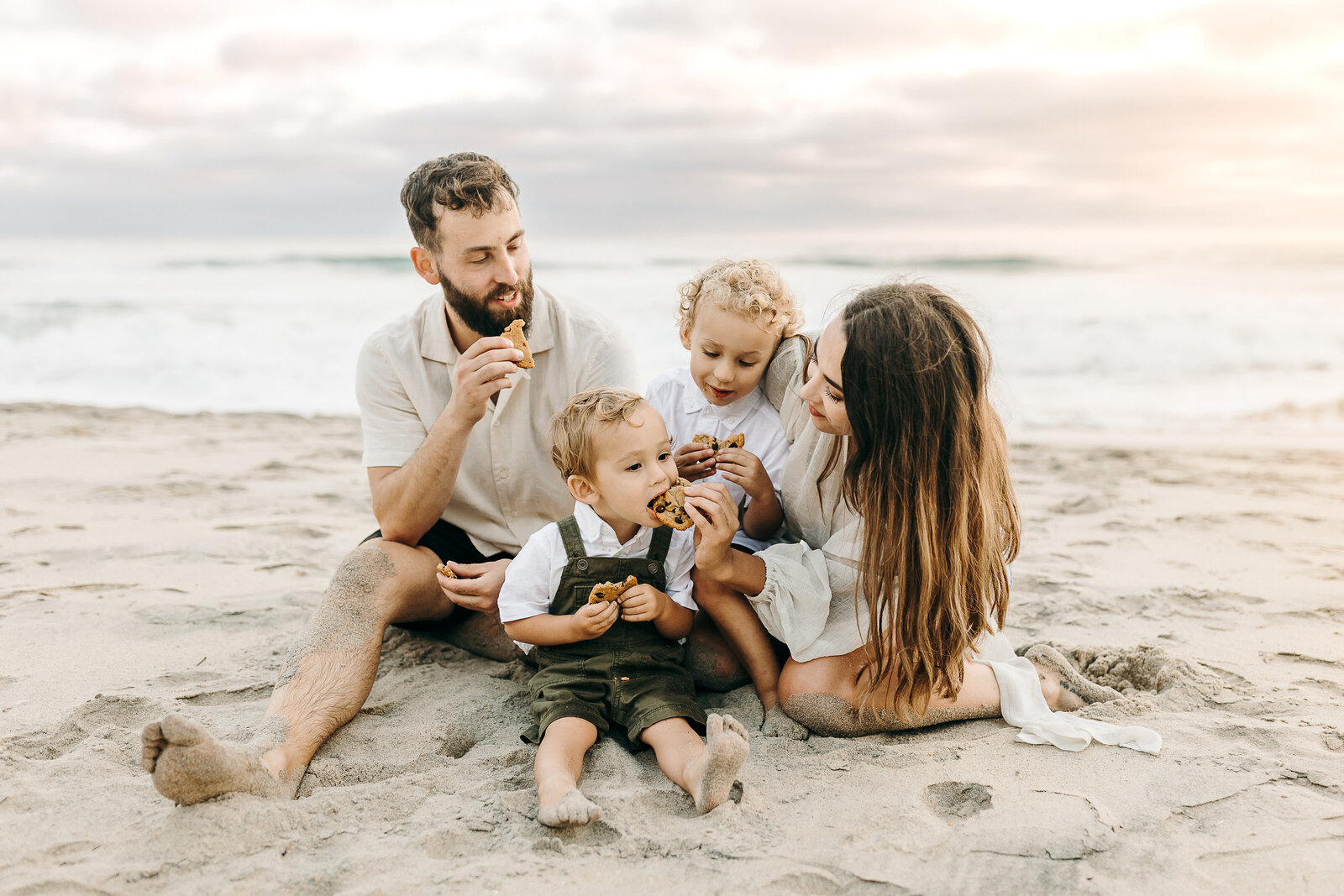 A family eating cookies on the beach