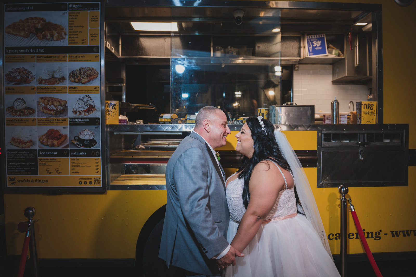 photo of bride and groom kissing in front of food truck during wedding at Sea Cliff Manor